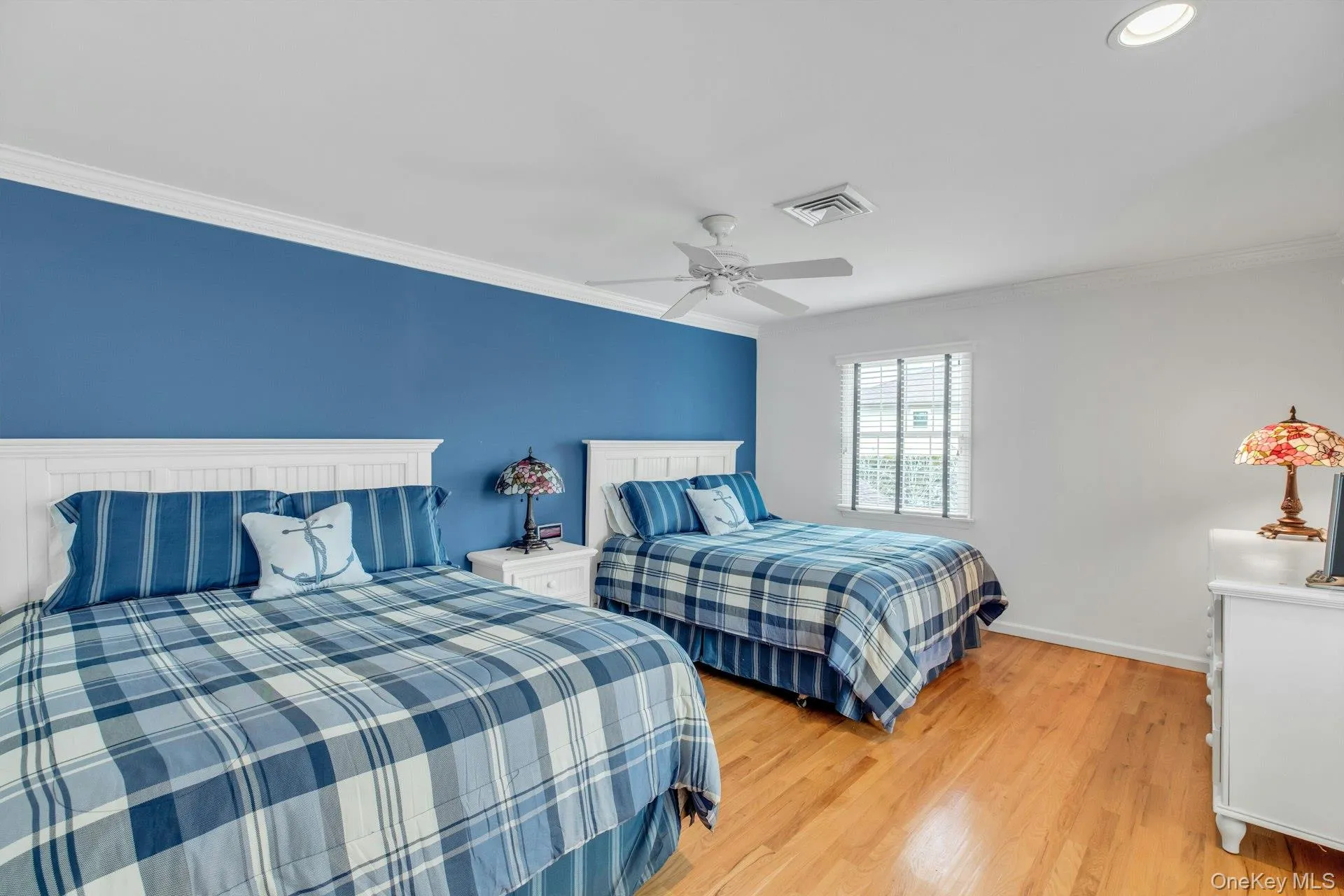 Bedroom featuring light wood-style floors, crown molding, and ceiling fan