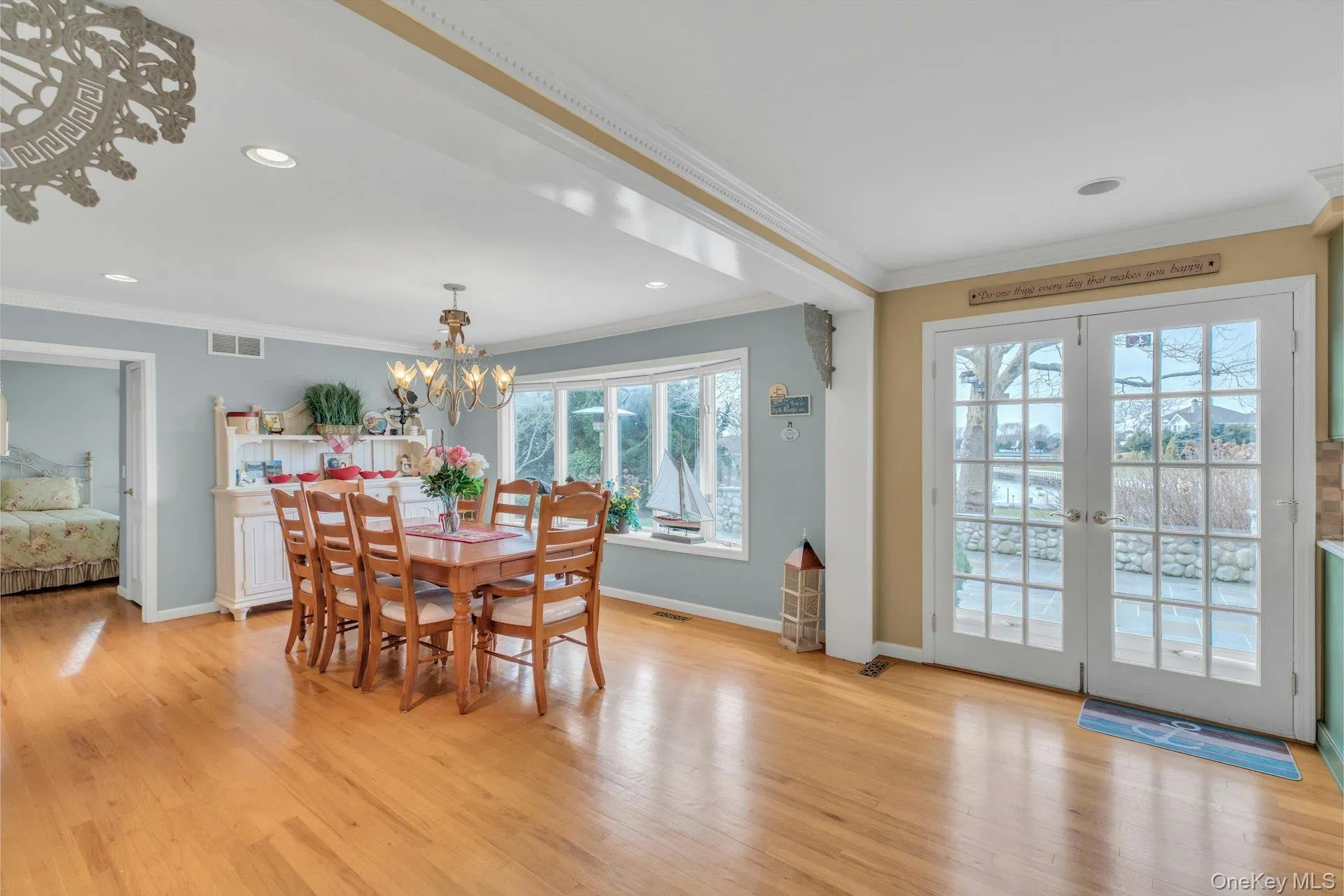 Dining space with light wood-type flooring, crown molding, recessed lighting, french doors, and a chandelier