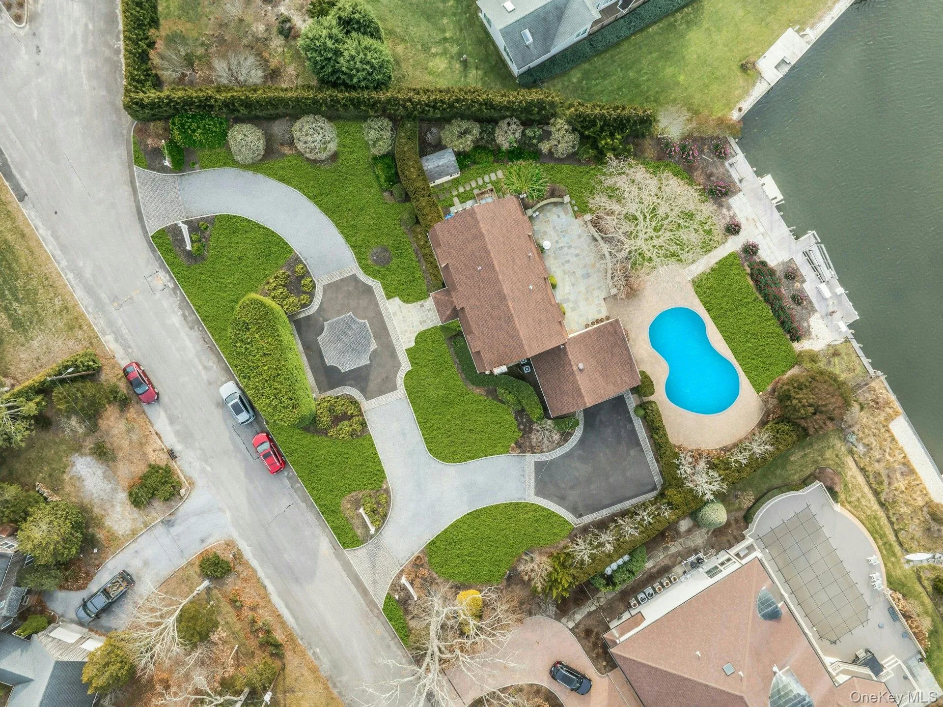 Aerial view of a pool area and a large body of water
