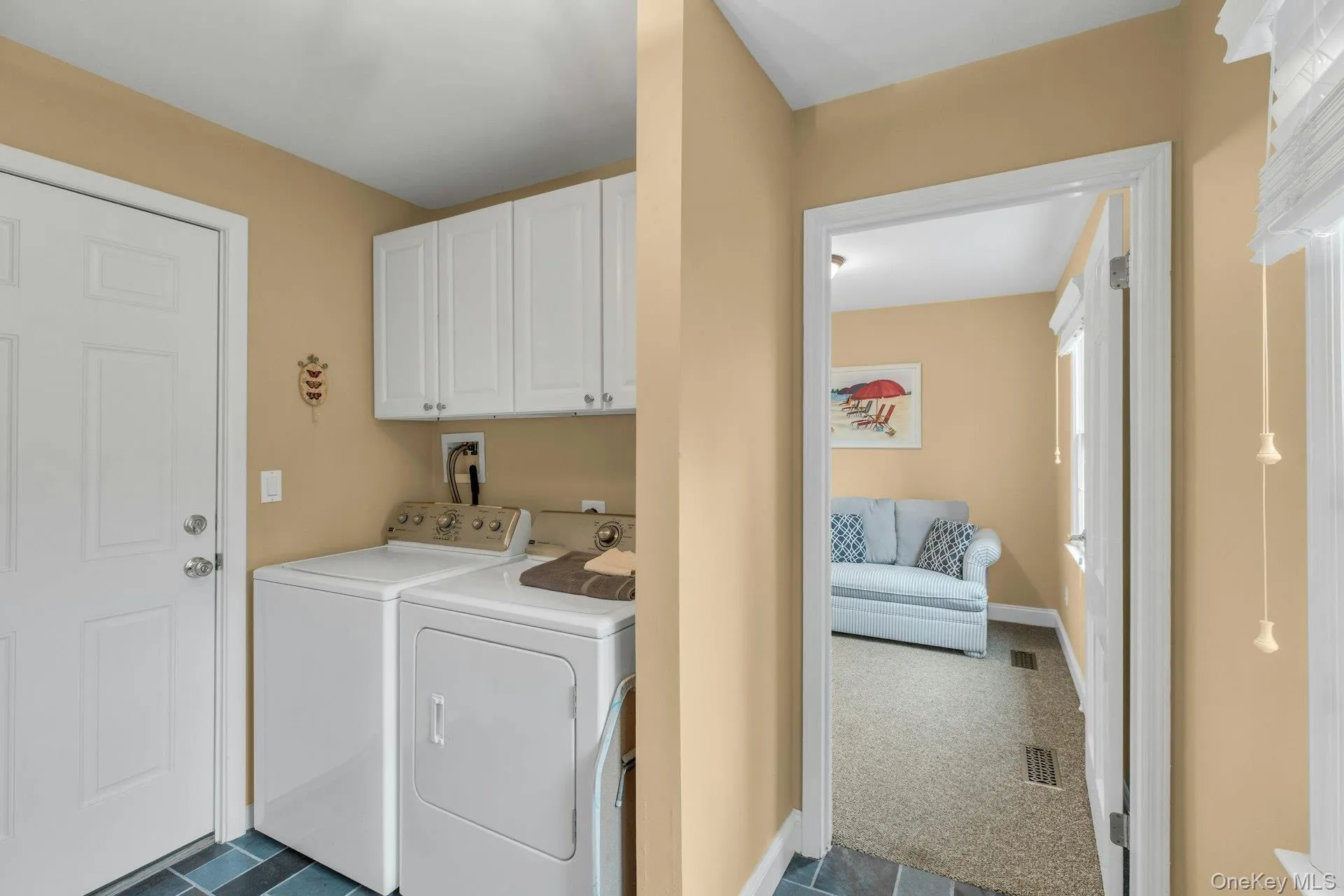 Laundry room with cabinet space, washer and clothes dryer, and dark carpet