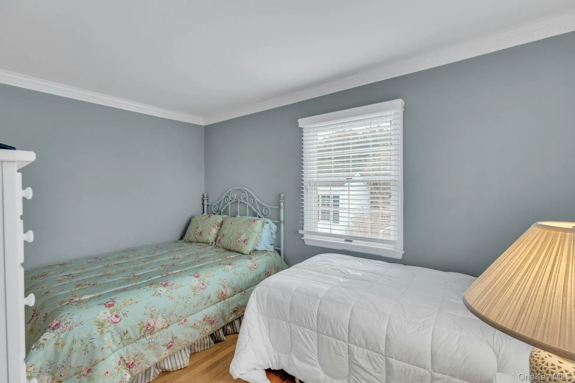 Bedroom with crown molding and wood finished floors