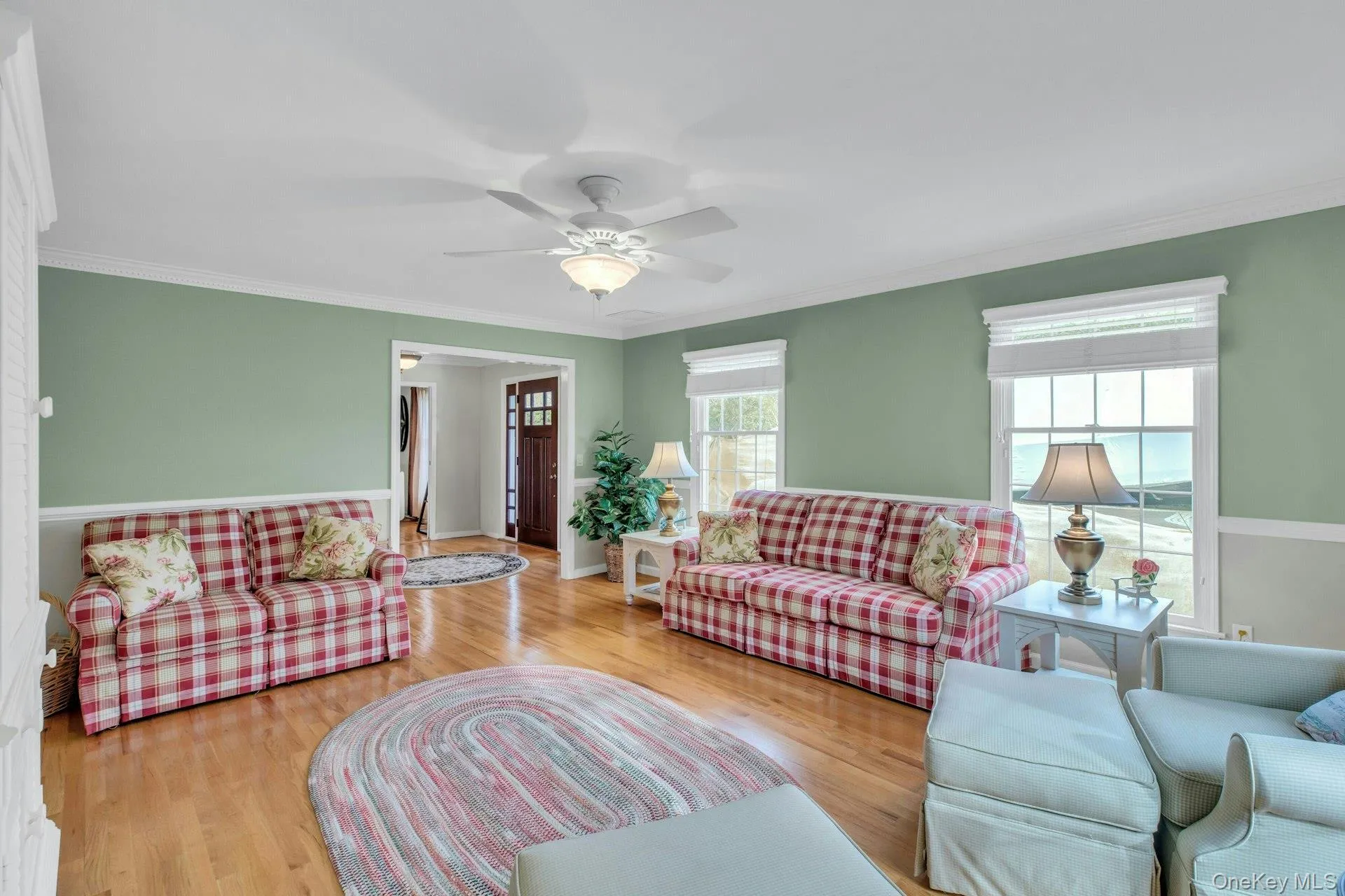 Living area featuring ornamental molding, wood finished floors, and ceiling fan