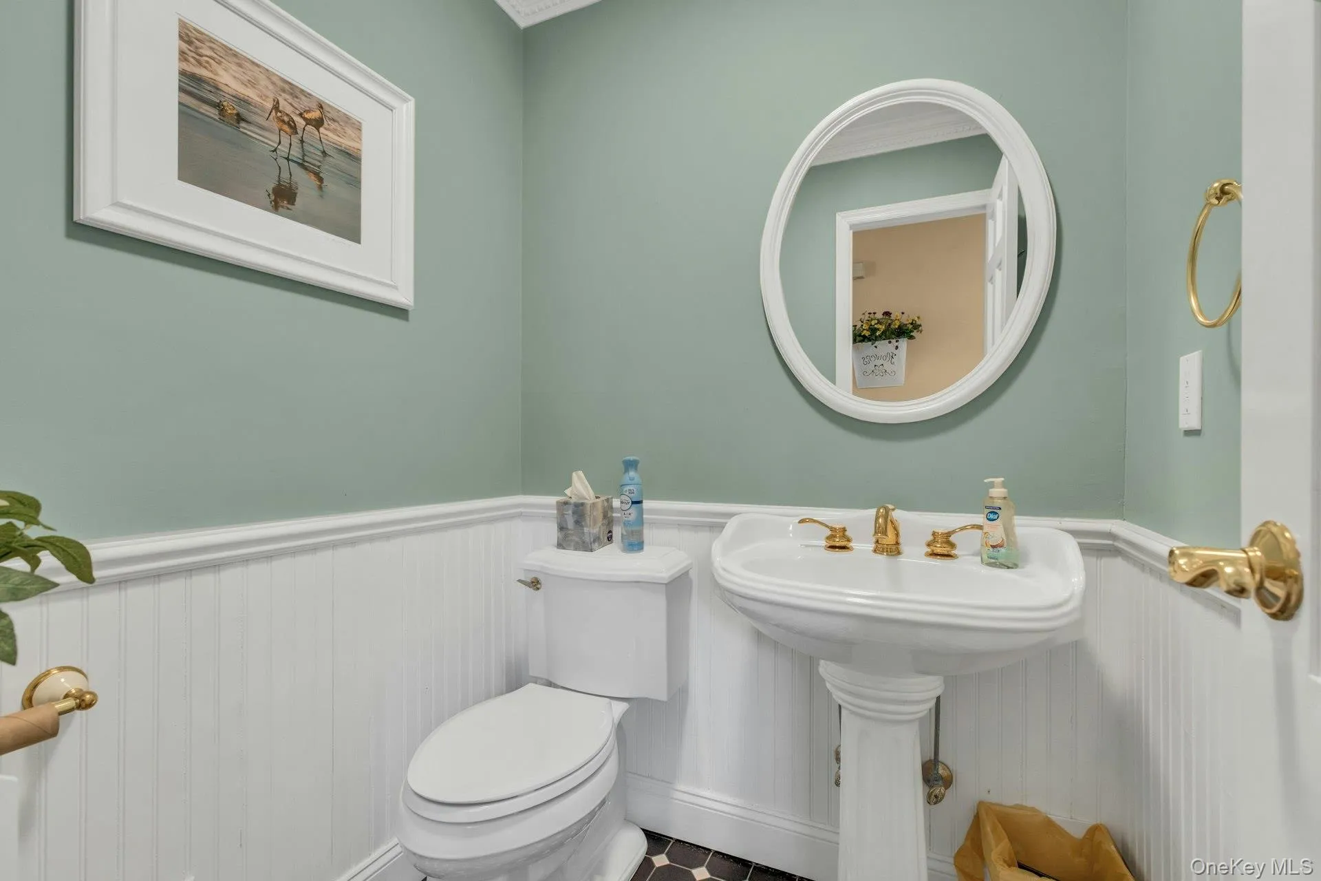 Half bathroom featuring wainscoting