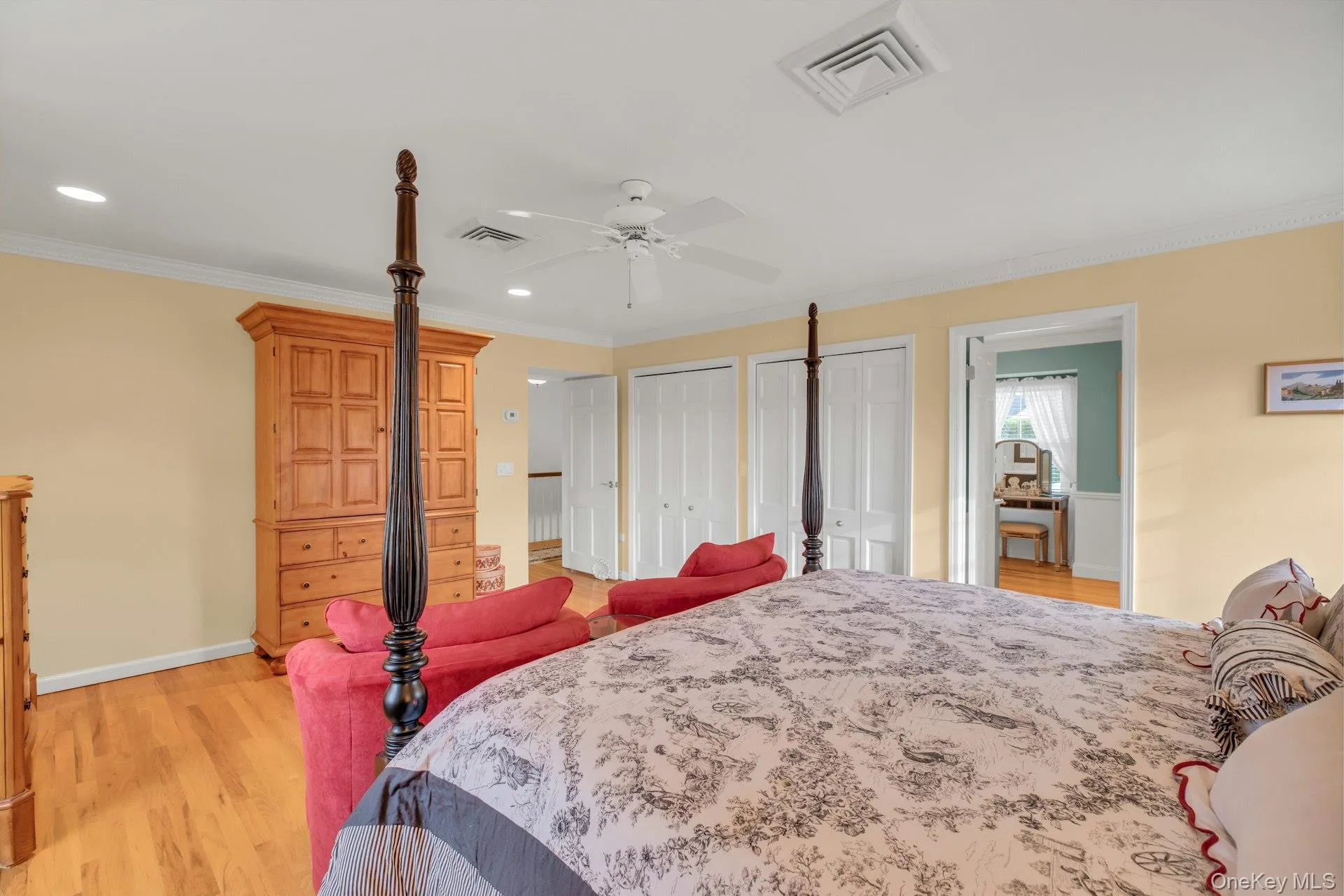 Bedroom with multiple closets, crown molding, light wood-style floors, recessed lighting, and a ceiling fan