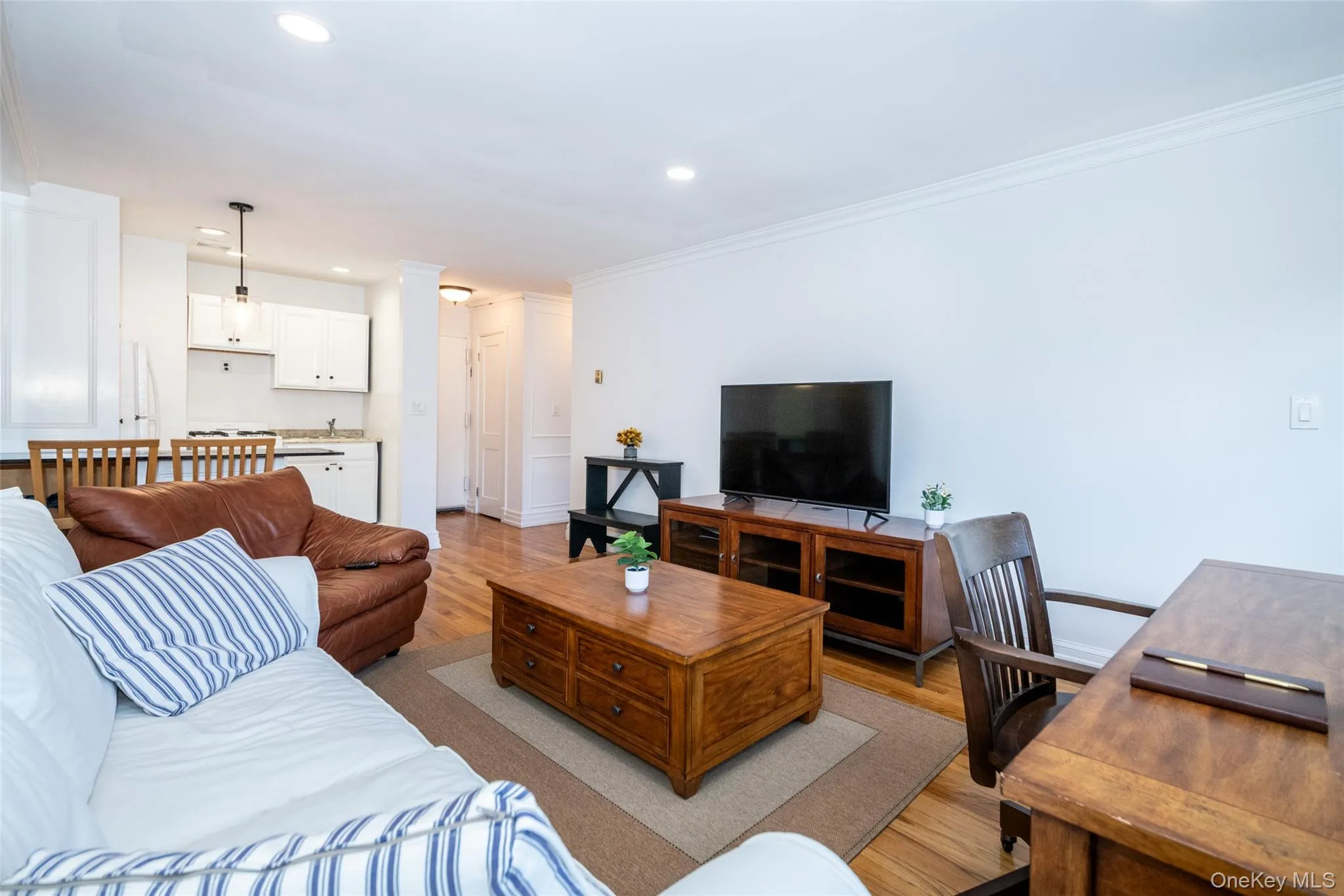 Living room featuring wood finished floors, recessed lighting, a desk, and ornamental molding Living room featuring wood finished floors, recessed lighting, a desk, and ornamental molding