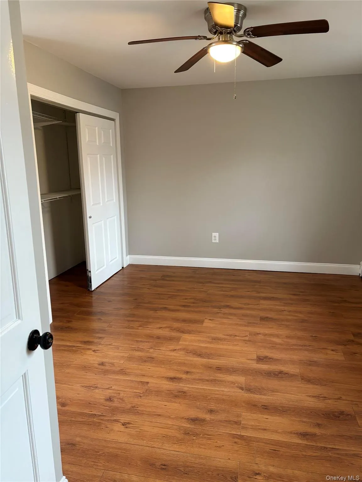 Unfurnished bedroom with wood finished floors, a closet, and a ceiling fan Unfurnished bedroom with wood finished floors, a closet, and a ceiling fan