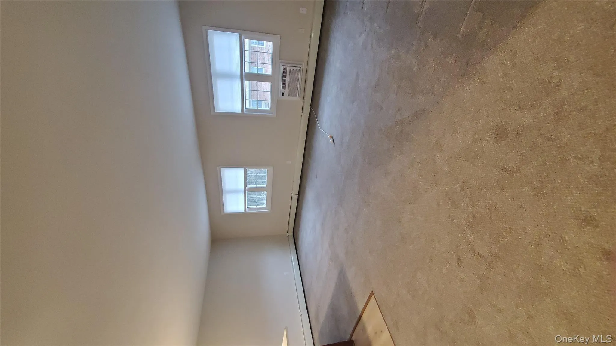 Spare room featuring healthy amount of natural light, carpet floors, and an AC wall unit Spare room featuring healthy amount of natural light, carpet floors, and an AC wall unit