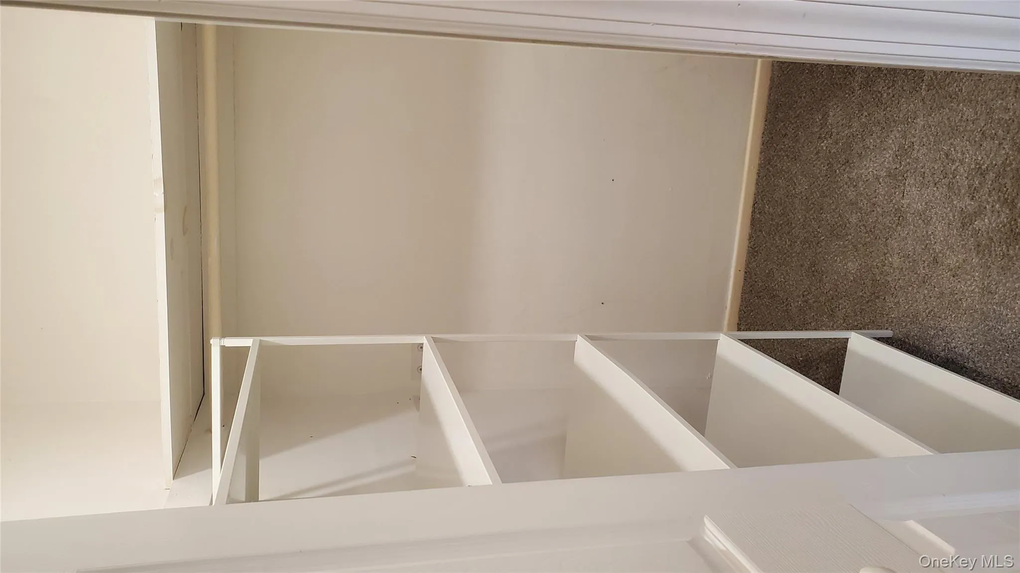 Spacious closet with dark colored carpet Spacious closet with dark colored carpet