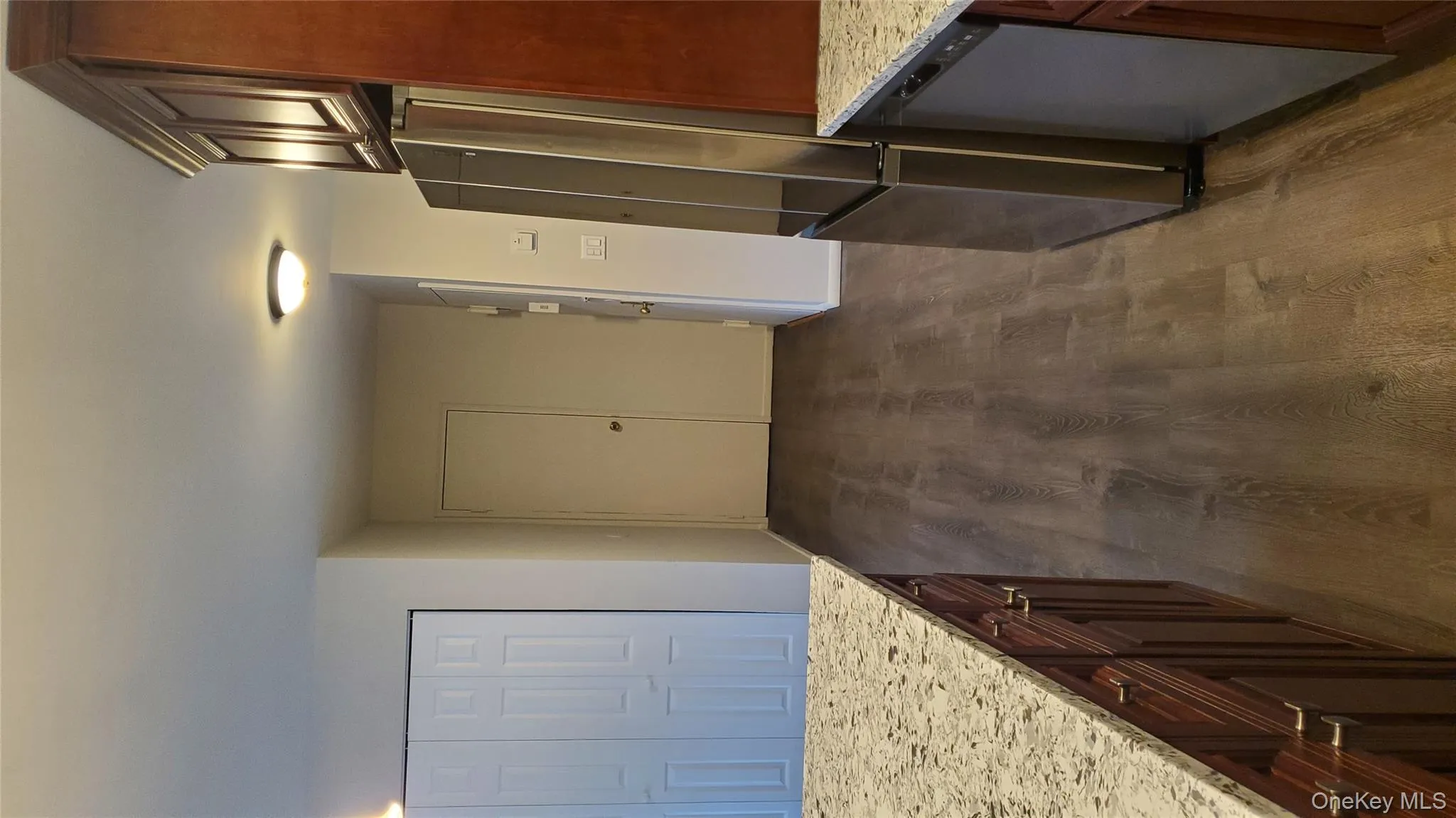 Kitchen featuring light stone countertops, stainless steel fridge, dark wood finished floors, and dishwasher Kitchen featuring light stone countertops, stainless steel fridge, dark wood finished floors, and dishwasher