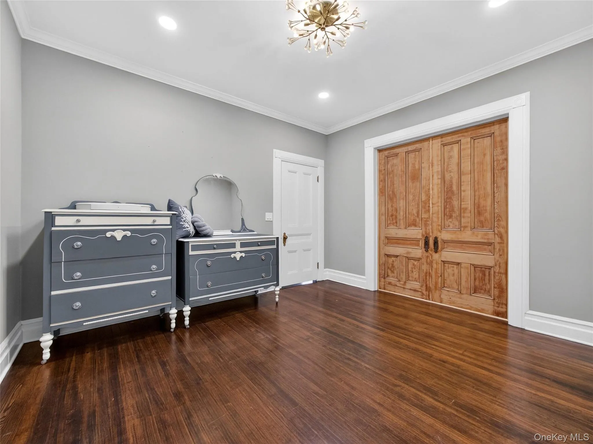 Bedroom featuring dark wood finished floors, crown molding, recessed lighting, a closet, and a chandelier Bedroom featuring dark wood finished floors, crown molding, recessed lighting, a closet, and a chandelier
