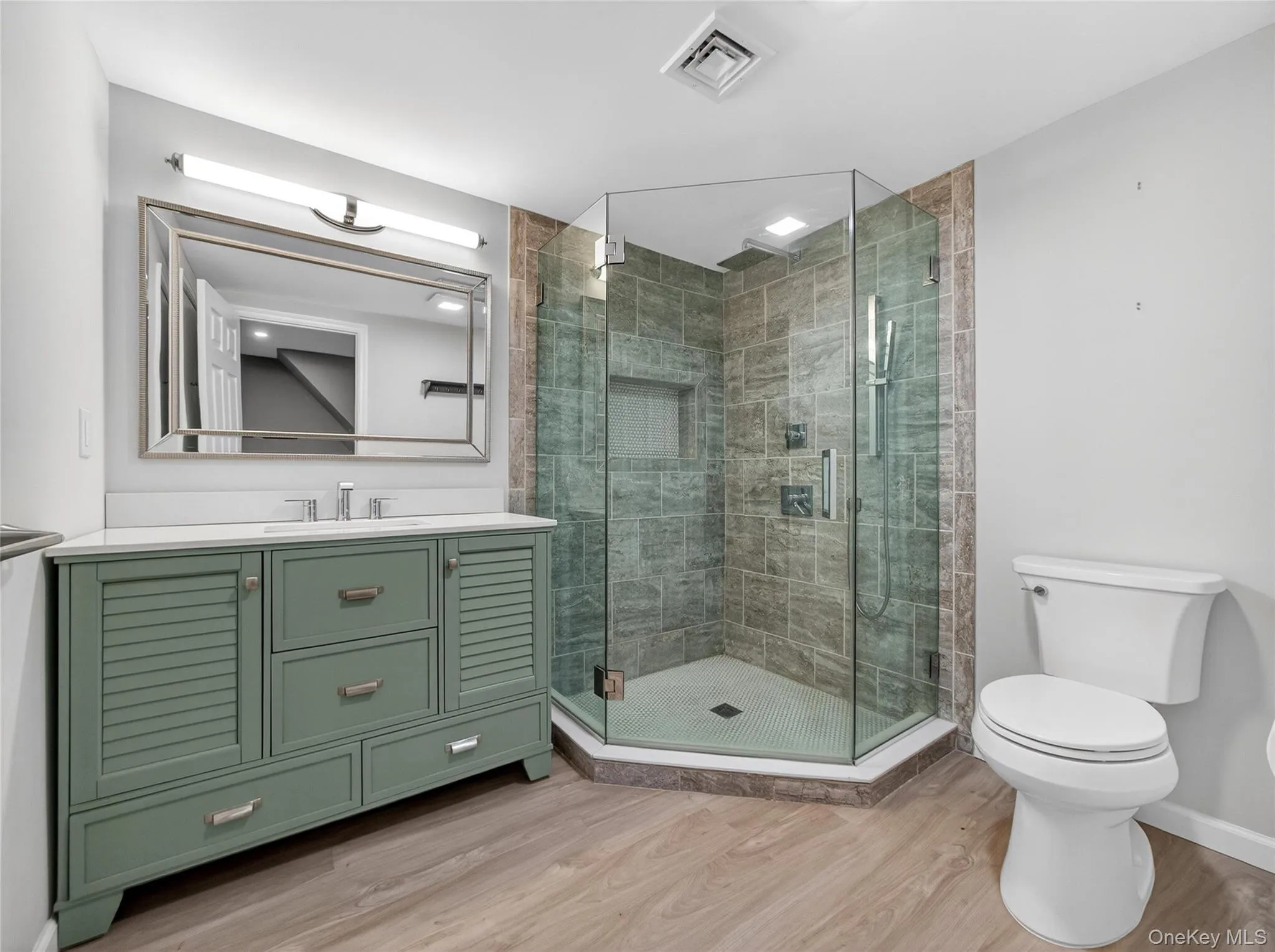 Bathroom with vanity, light wood-style flooring, and a stall shower Bathroom with vanity, light wood-style flooring, and a stall shower