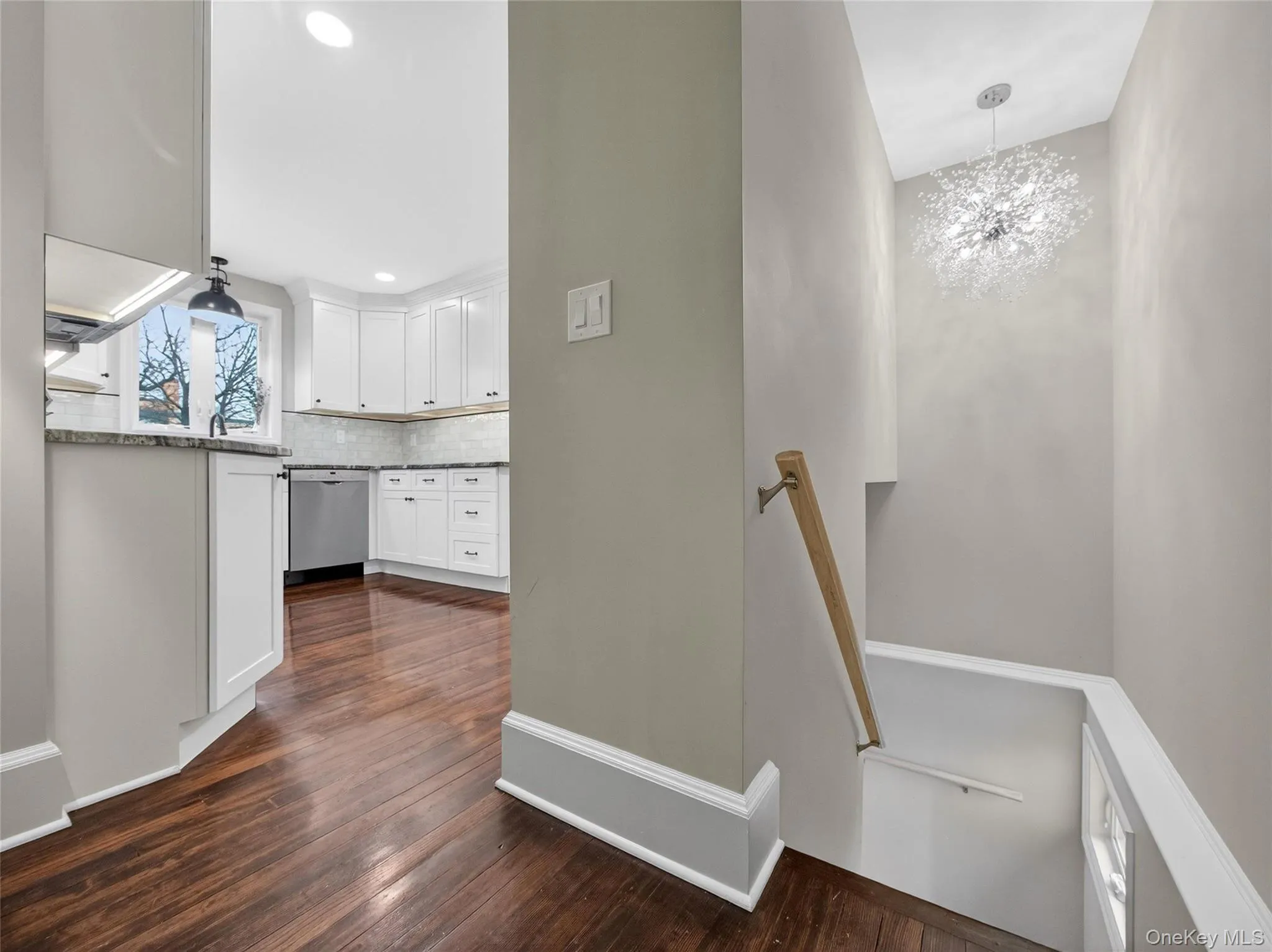 Staircase with a chandelier and hardwood / wood-style flooring Staircase with a chandelier and hardwood / wood-style flooring