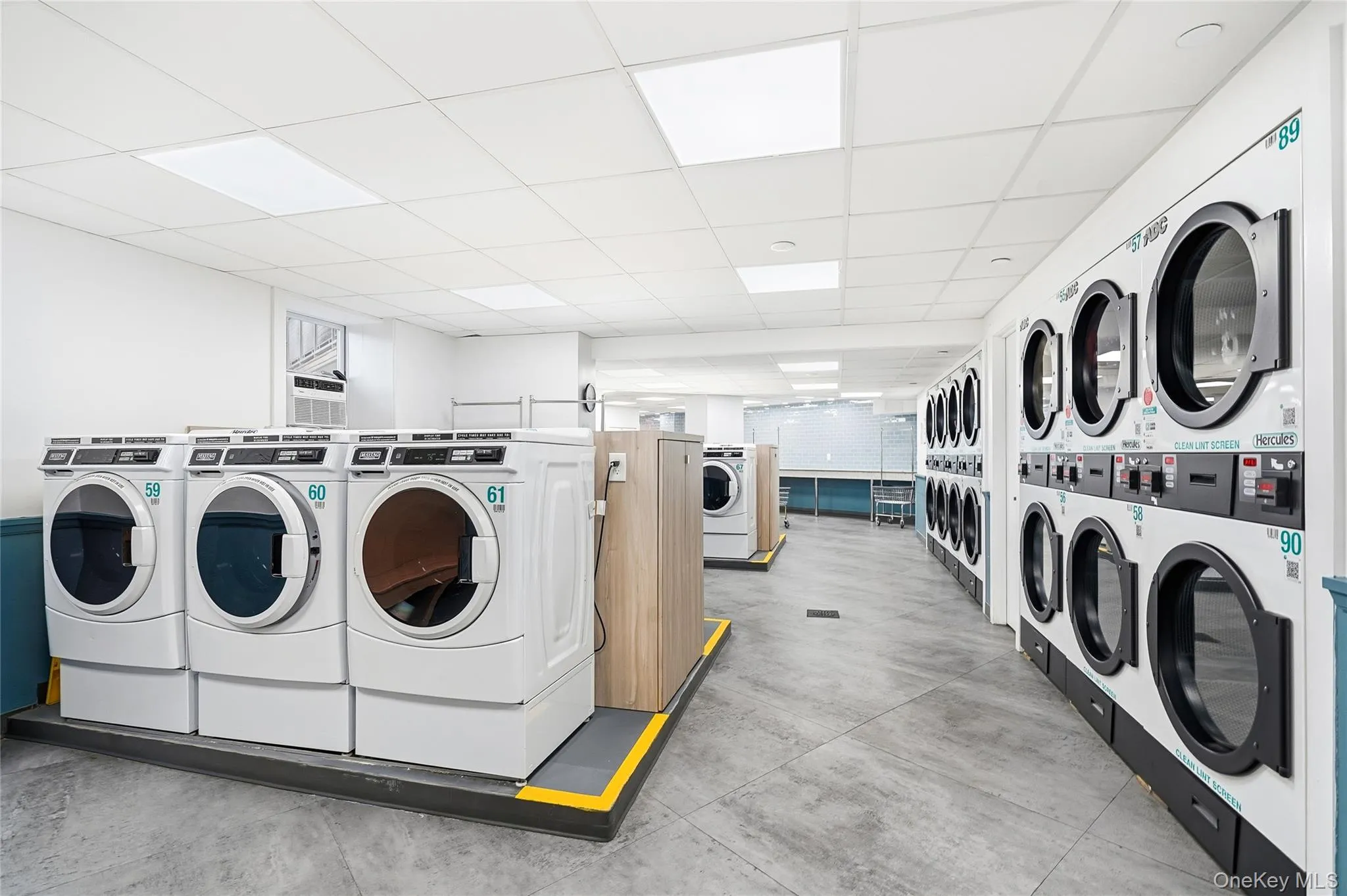 Community laundry room with a paneled ceiling and separate washer and dryer Community laundry room with a paneled ceiling and separate washer and dryer
