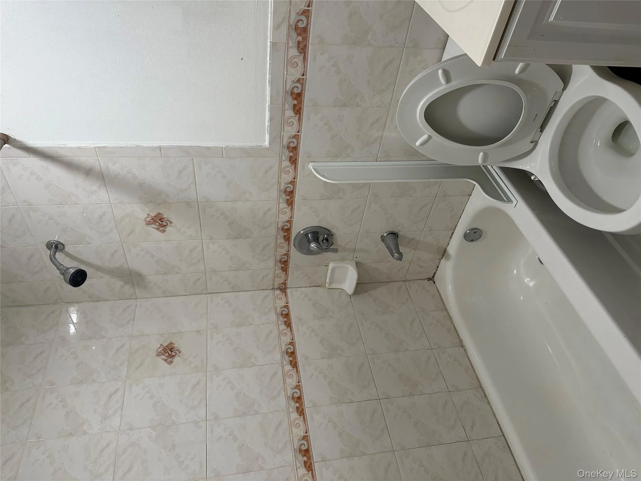 Full bathroom with bathing tub / shower combination, vanity, and tile walls Full bathroom with bathing tub / shower combination, vanity, and tile walls
