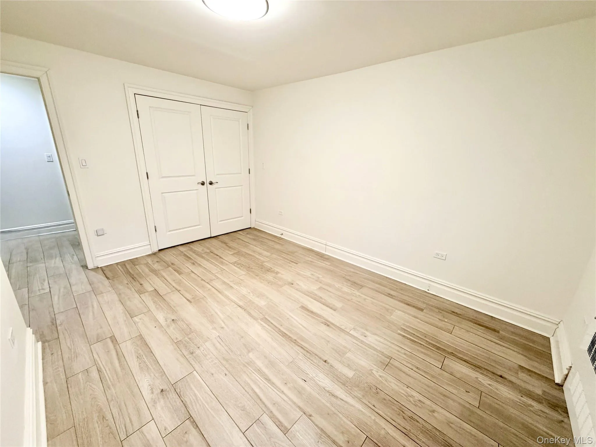 Master bedroom with light wood-style floors and a closet Master bedroom with light wood-style floors and a closet