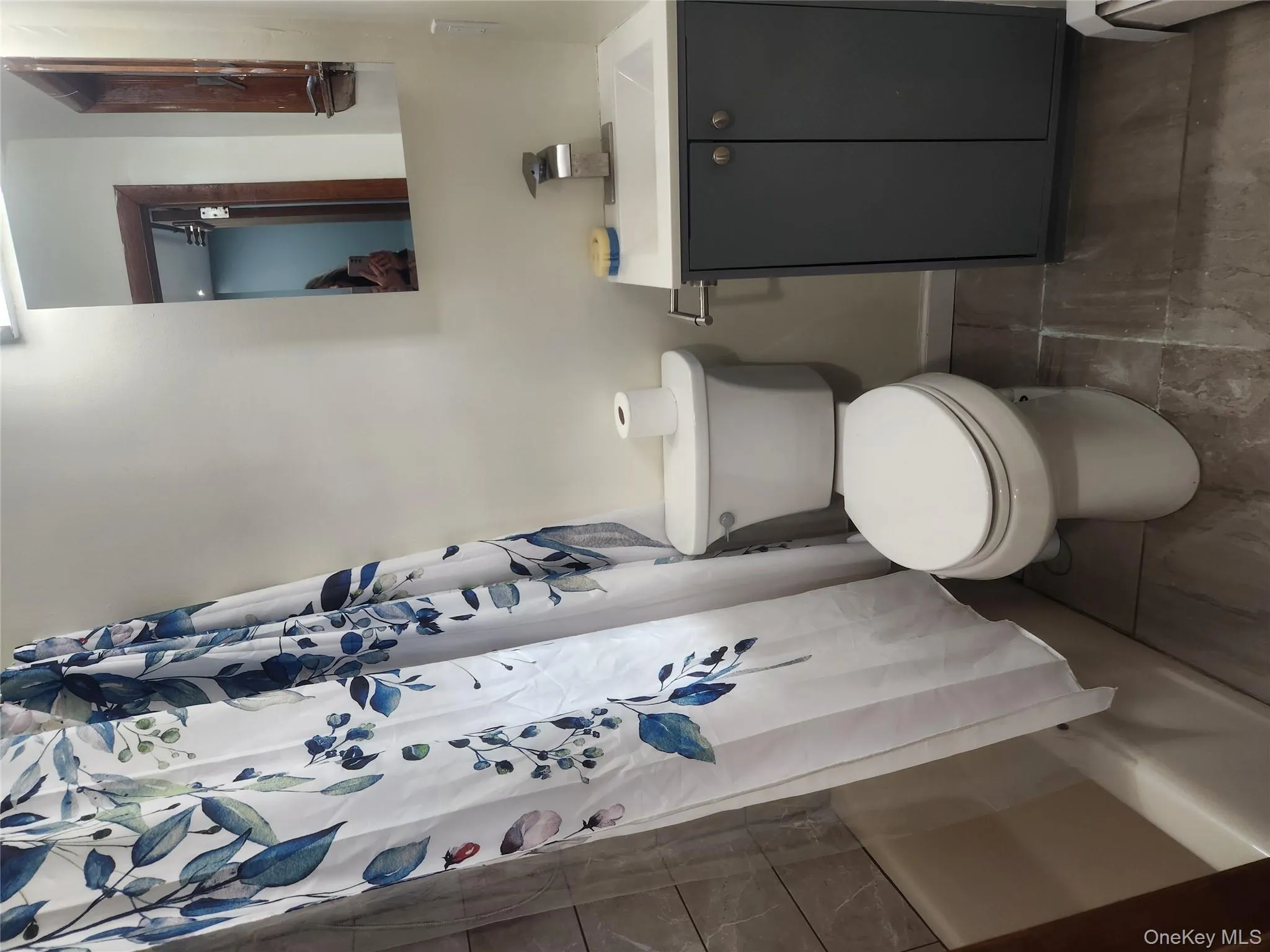 Bathroom with shower / bathtub combination with curtain, vanity, and baseboard heating Bathroom with shower / bathtub combination with curtain, vanity, and baseboard heating