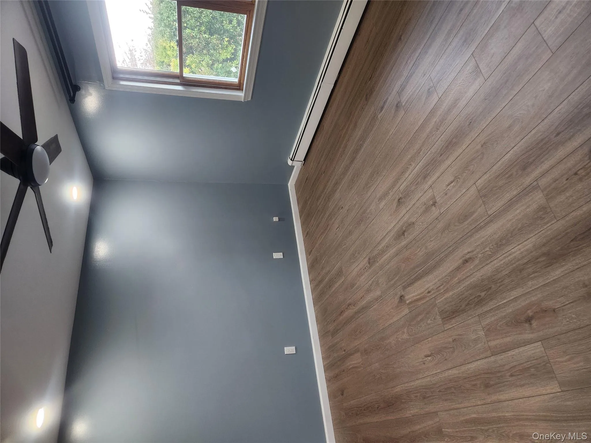 Empty room with a baseboard radiator, wood finished floors, a ceiling fan, and recessed lighting Empty room with a baseboard radiator, wood finished floors, a ceiling fan, and recessed lighting
