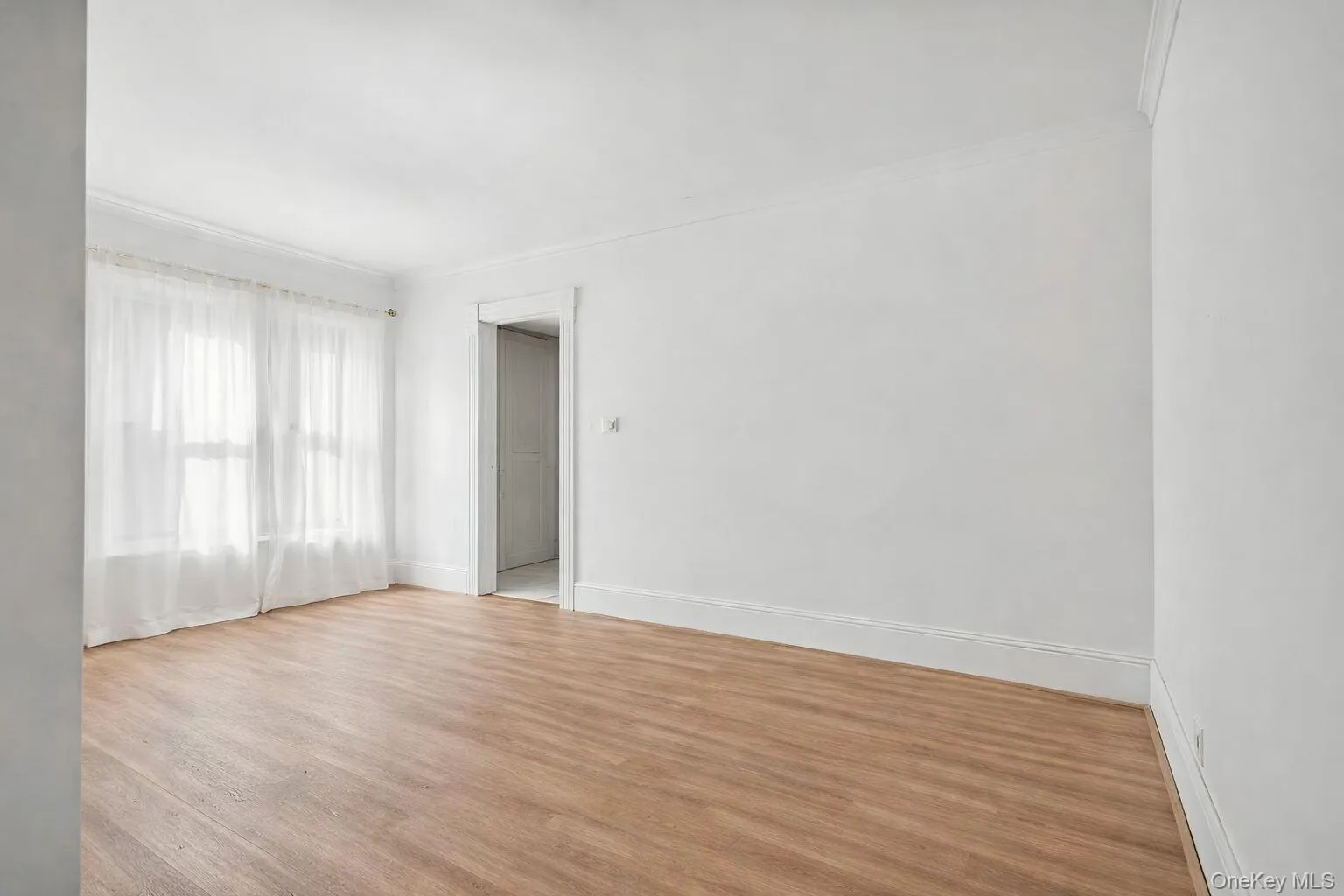 Unfurnished room featuring wood finished floors and crown molding Unfurnished room featuring wood finished floors and crown molding