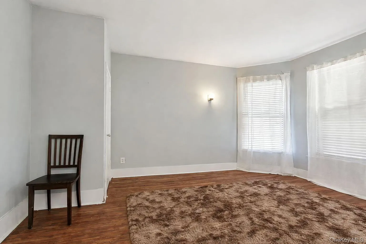 Empty room featuring dark wood-style flooring and baseboards Empty room featuring dark wood-style flooring and baseboards