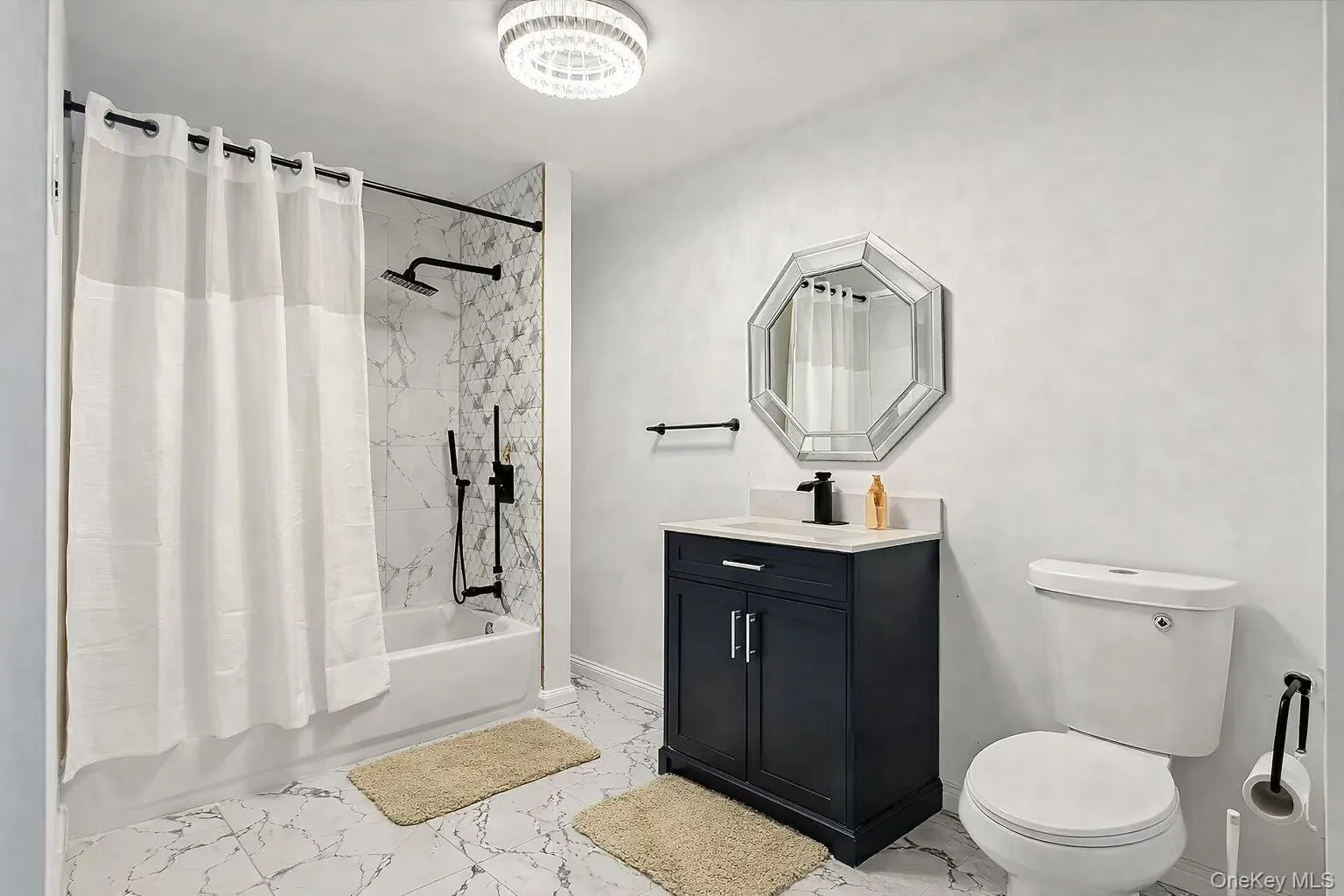 Full bath with shower / tub combo with curtain, light marble finish floors, and vanity Full bath with shower / tub combo with curtain, light marble finish floors, and vanity