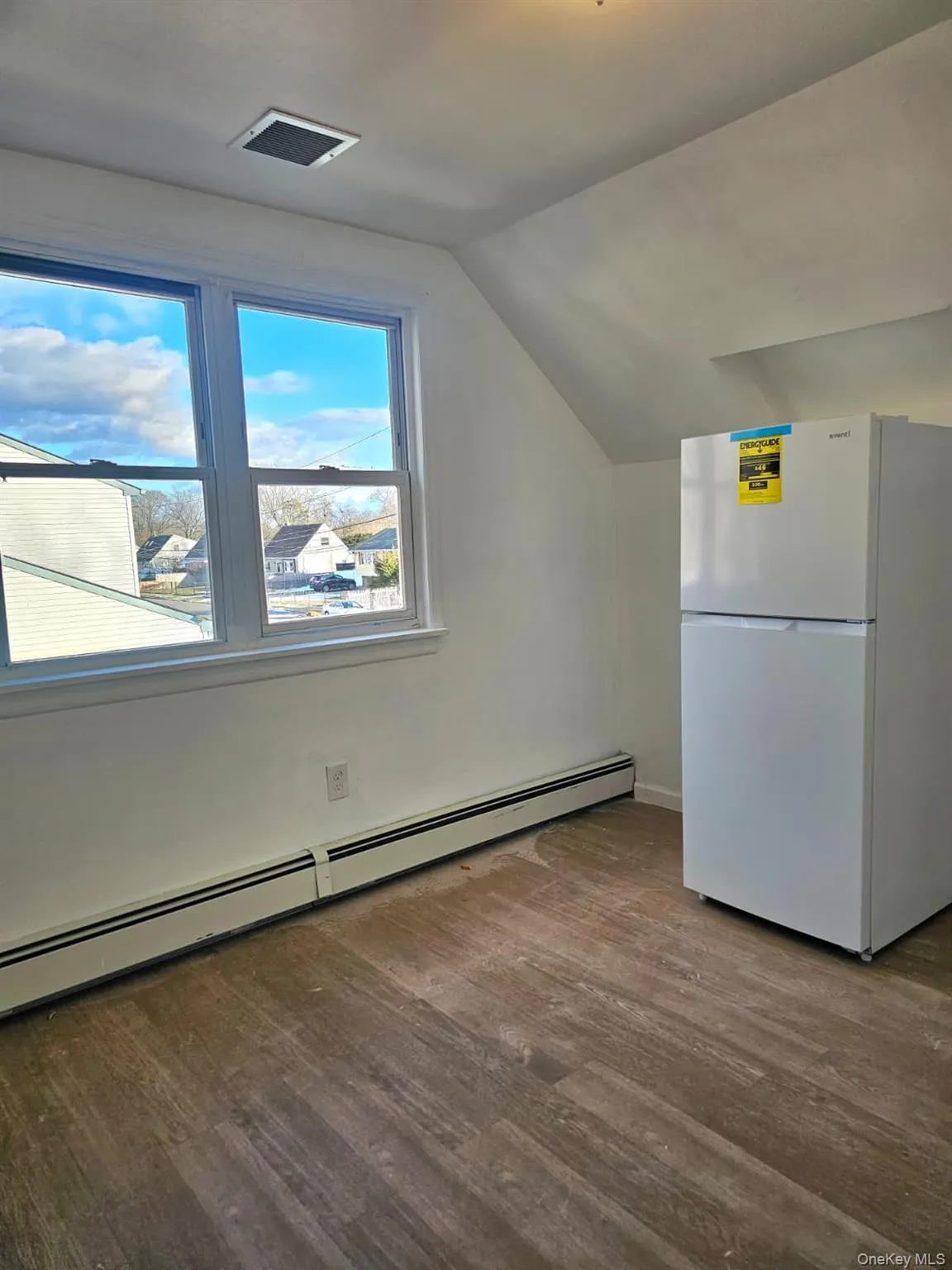Bonus room featuring baseboard heating, lofted ceiling, and light wood finished floors Bonus room featuring baseboard heating, lofted ceiling, and light wood finished floors