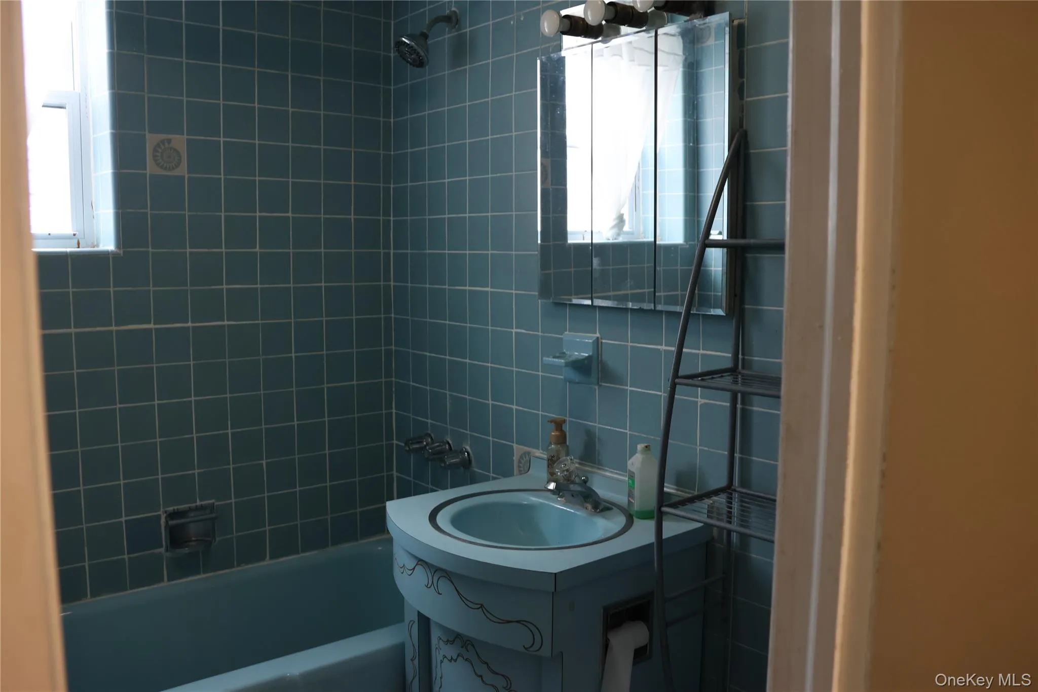 Bathroom with vanity, washtub / shower combination, and tile walls Bathroom with vanity, washtub / shower combination, and tile walls