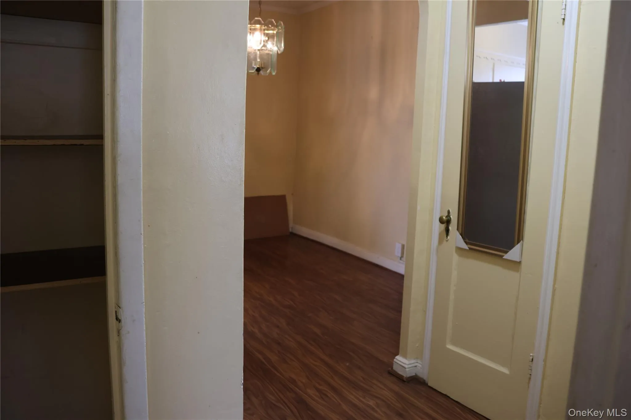 Hallway featuring a chandelier and dark wood-style flooring Hallway featuring a chandelier and dark wood-style flooring