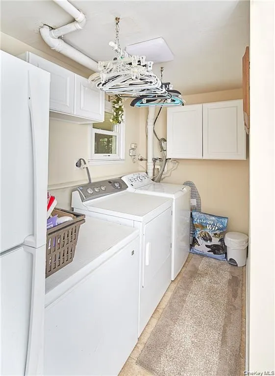 Laundry room featuring cabinet space and washer and dryer Laundry room featuring cabinet space and washer and dryer