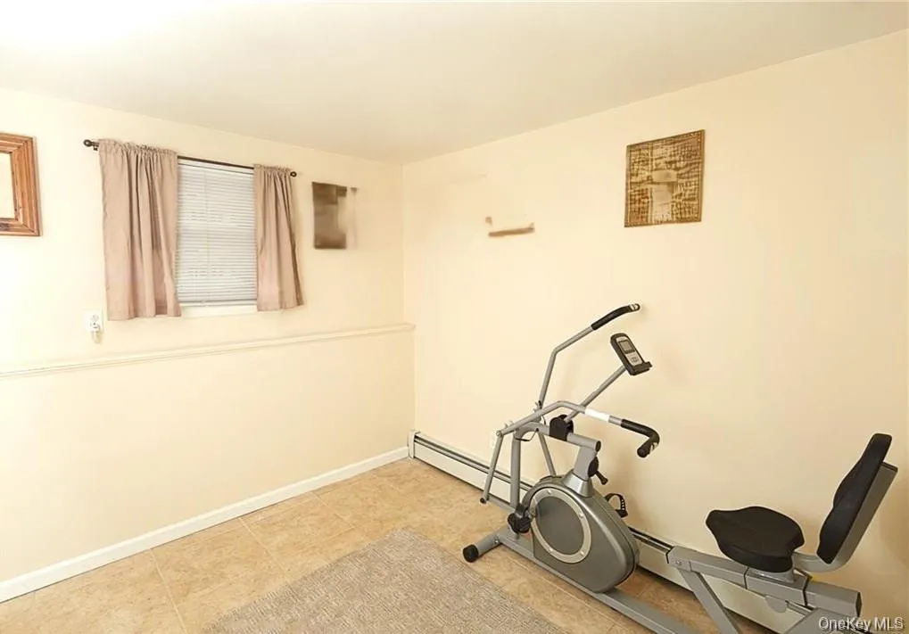 Workout room with a baseboard radiator and tile patterned floors Workout room with a baseboard radiator and tile patterned floors