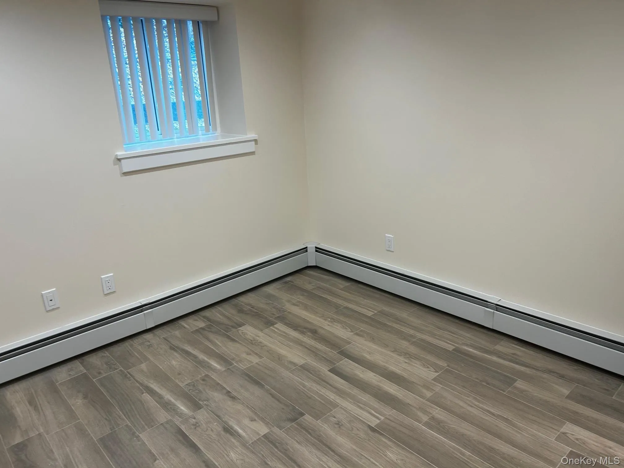 Bedroom with baseboard heating and wood finish floors Bedroom with baseboard heating and wood finish floors