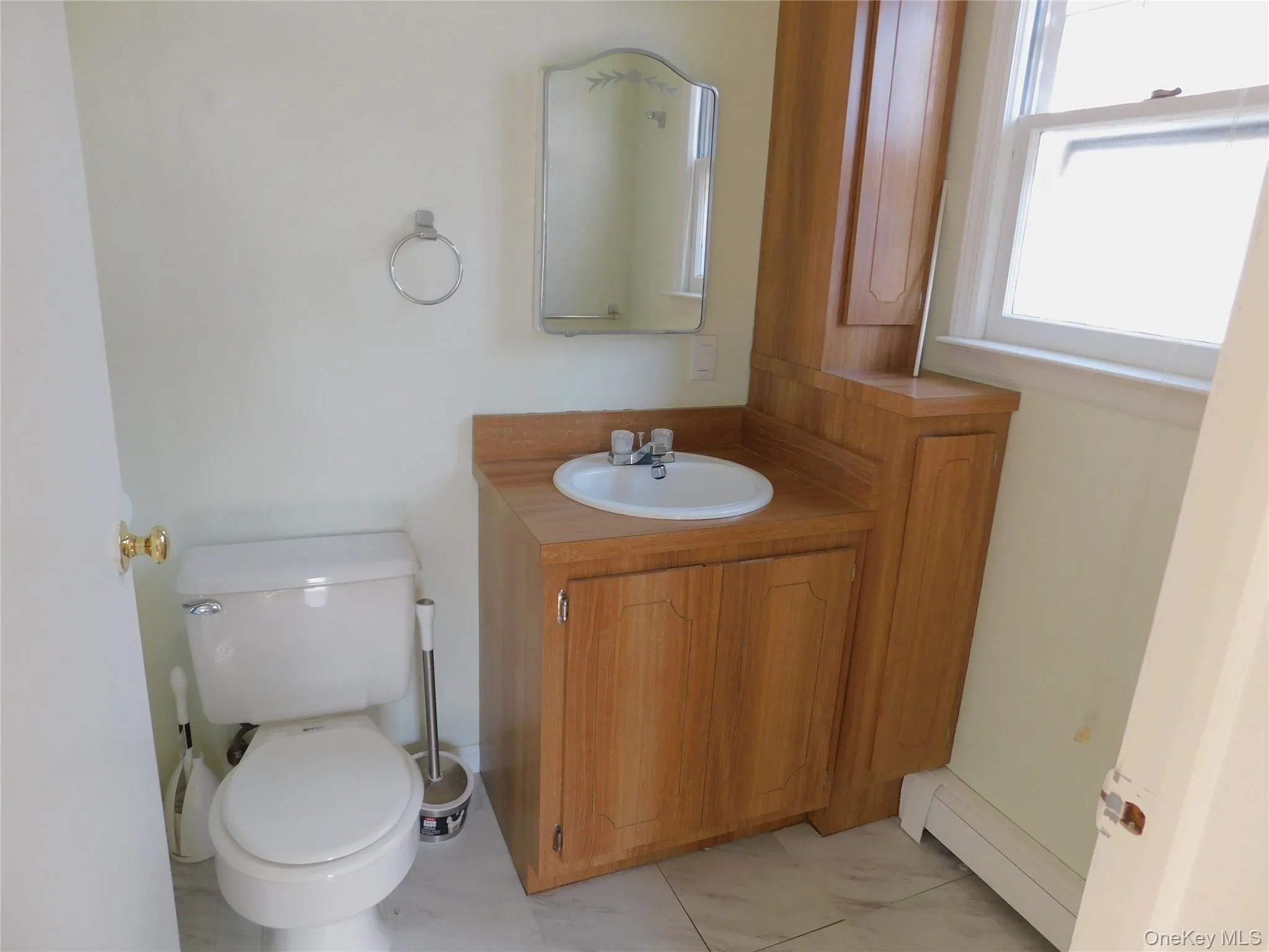 Bathroom with vanity, light marble finish floors, and a baseboard radiator Bathroom with vanity, light marble finish floors, and a baseboard radiator