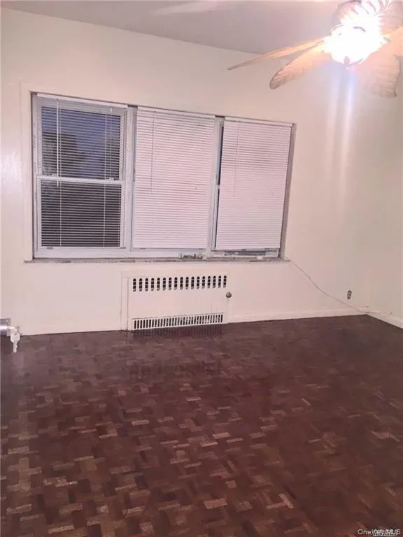 Empty room with radiator and a ceiling fan Empty room with radiator and a ceiling fan