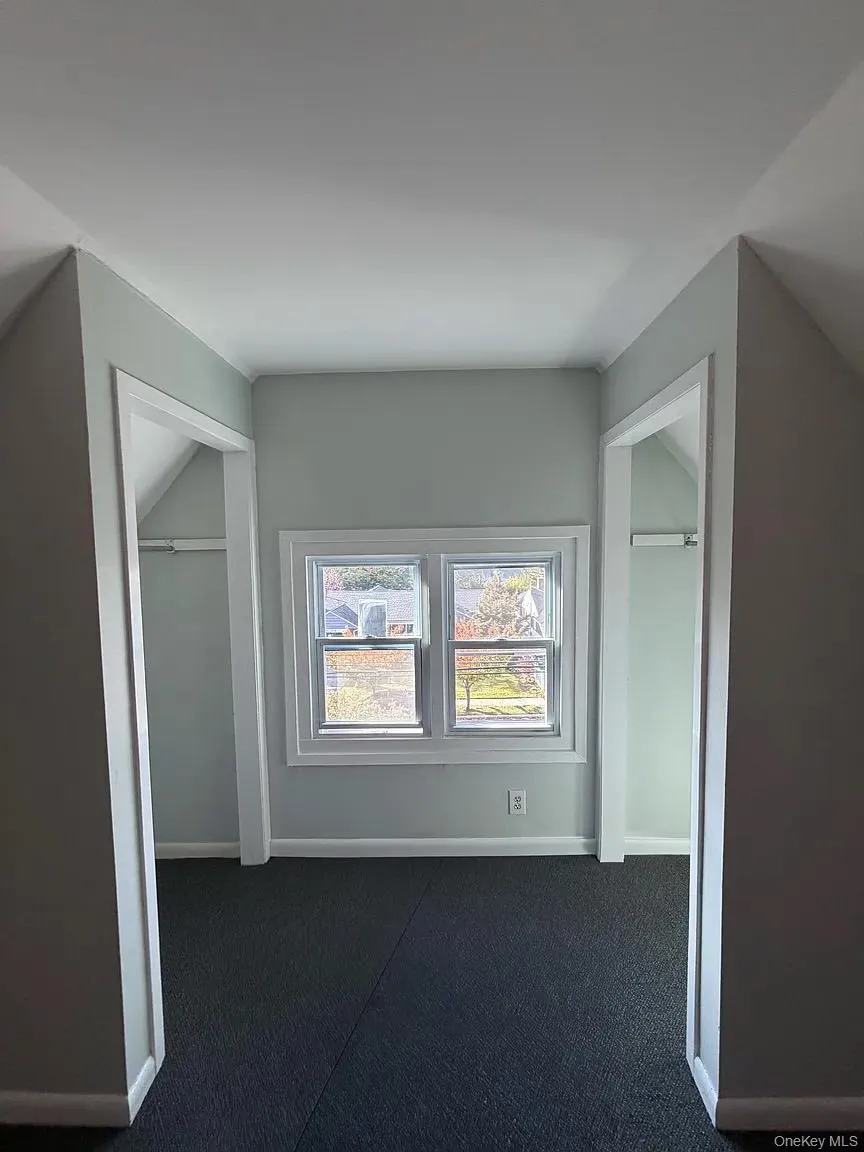 Unfurnished bedroom featuring carpet floors and lofted ceiling Unfurnished bedroom featuring carpet floors and lofted ceiling
