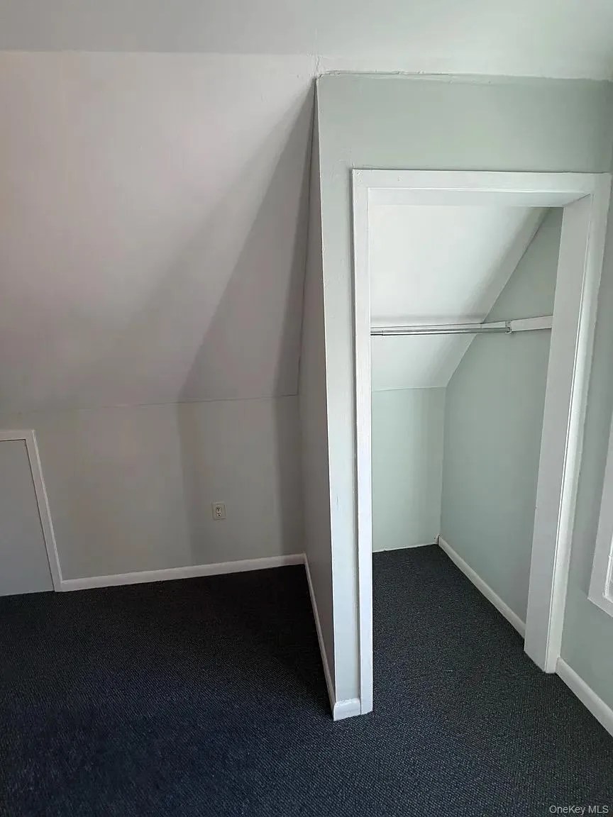 Bonus room with dark colored carpet and lofted ceiling Bonus room with dark colored carpet and lofted ceiling