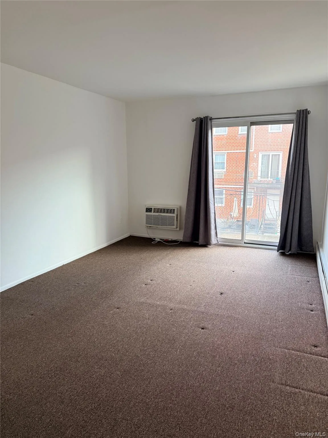 Carpeted spare room with baseboards and a baseboard radiator Carpeted spare room with baseboards and a baseboard radiator