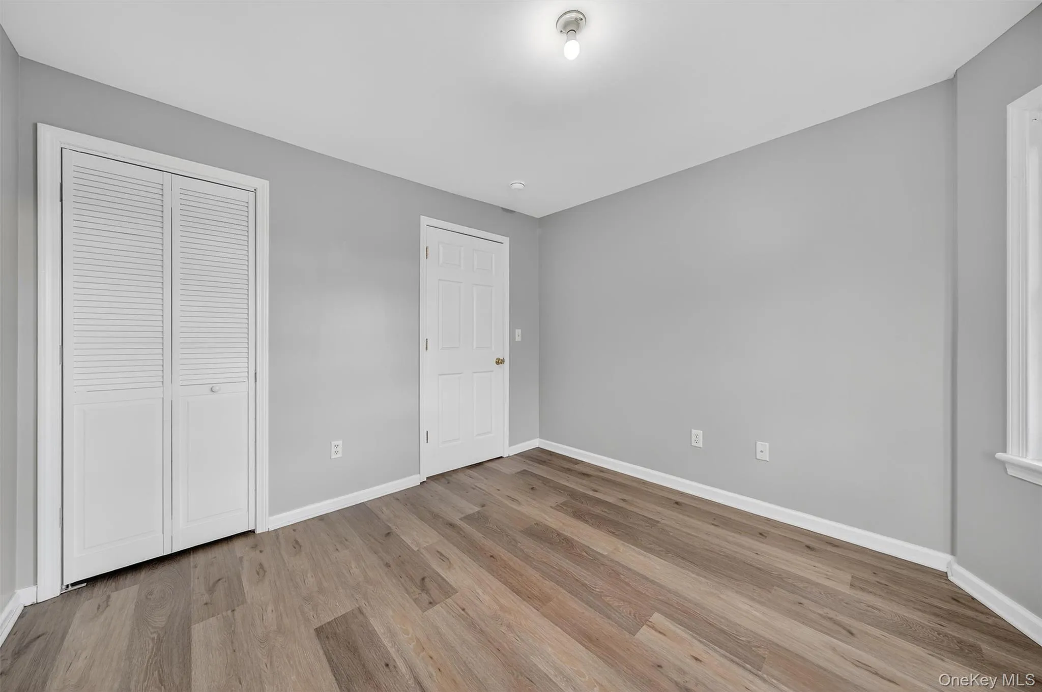 Unfurnished bedroom featuring light wood finished floors and a closet Unfurnished bedroom featuring light wood finished floors and a closet