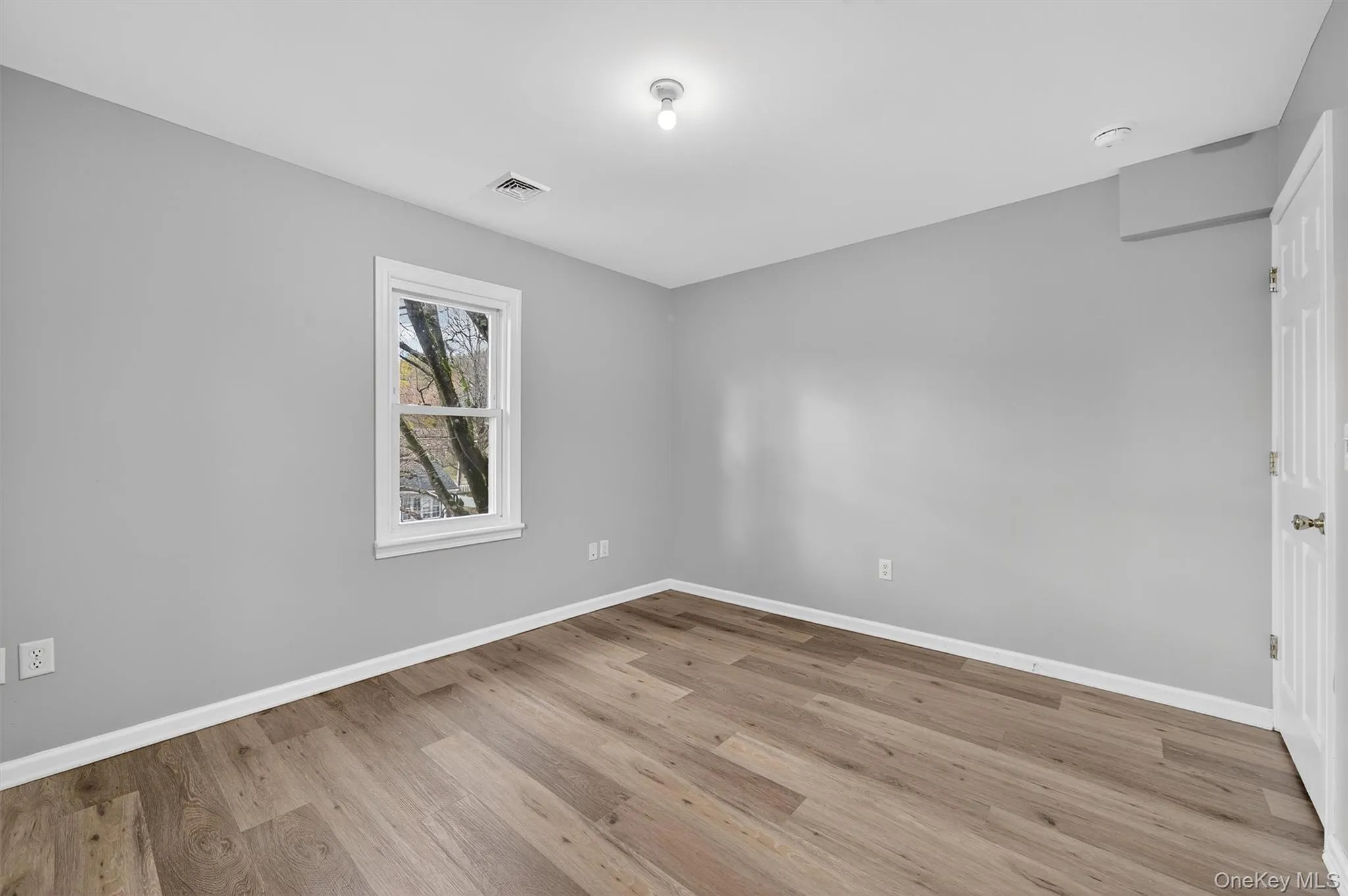 Spare room with light wood-type flooring and baseboards Spare room with light wood-type flooring and baseboards