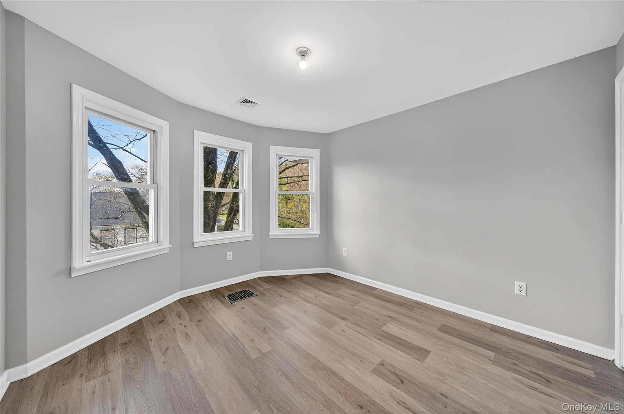Spare room with baseboards and light wood-style flooring Spare room with baseboards and light wood-style flooring