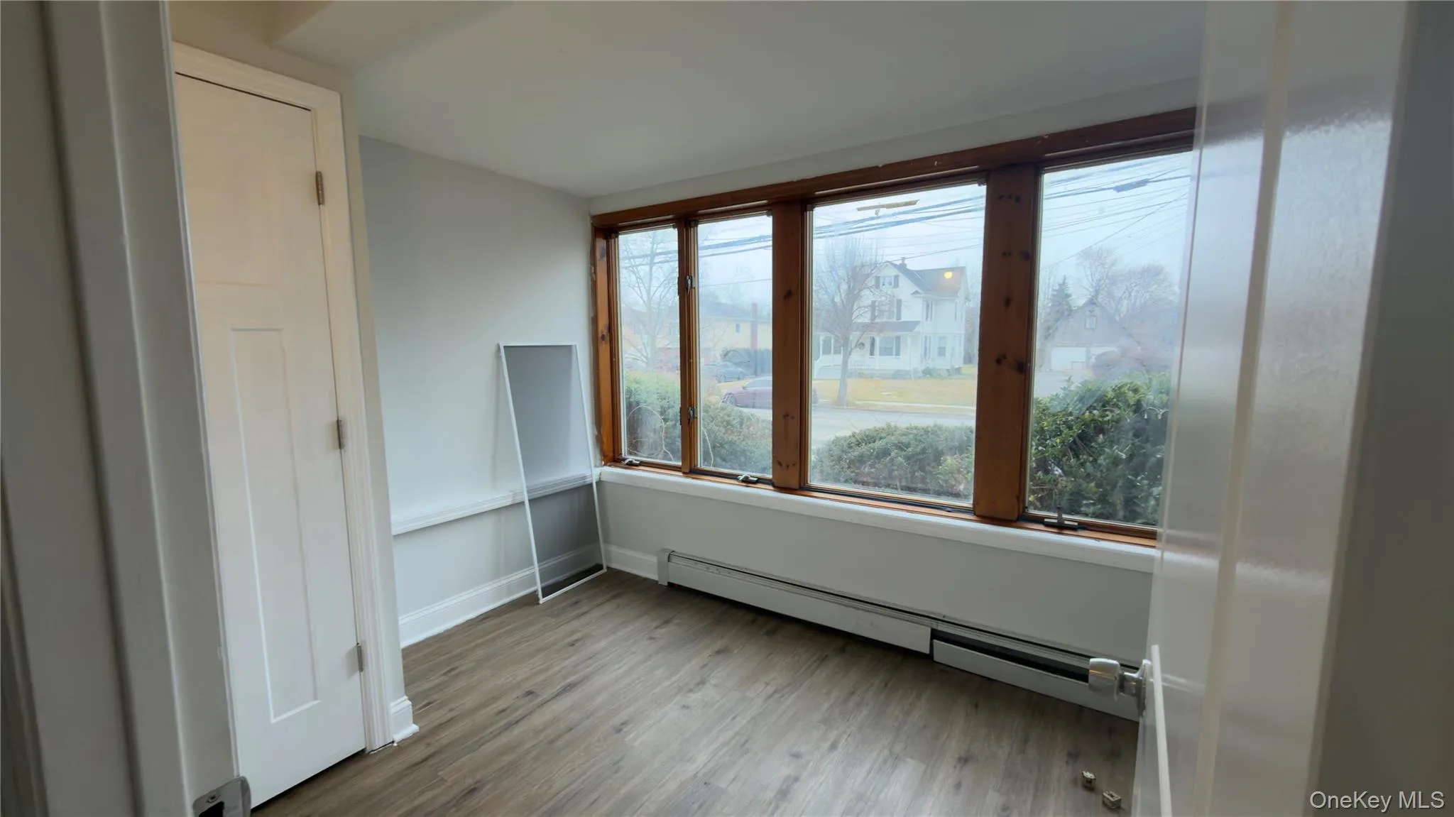 Spare room featuring a baseboard heating unit and wood finished floors Spare room featuring a baseboard heating unit and wood finished floors