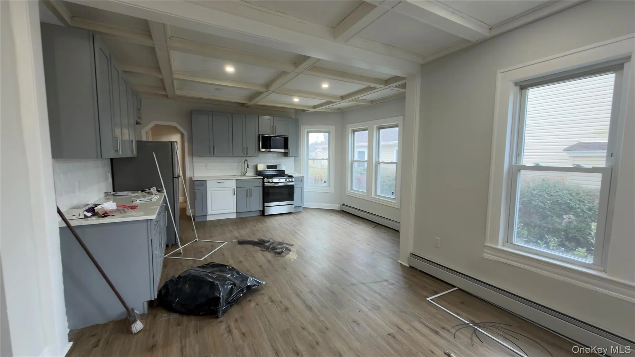 Kitchen with gray cabinets, baseboard heating, coffered ceiling, beam ceiling, and tasteful backsplash Kitchen with gray cabinets, baseboard heating, coffered ceiling, beam ceiling, and tasteful backsplash