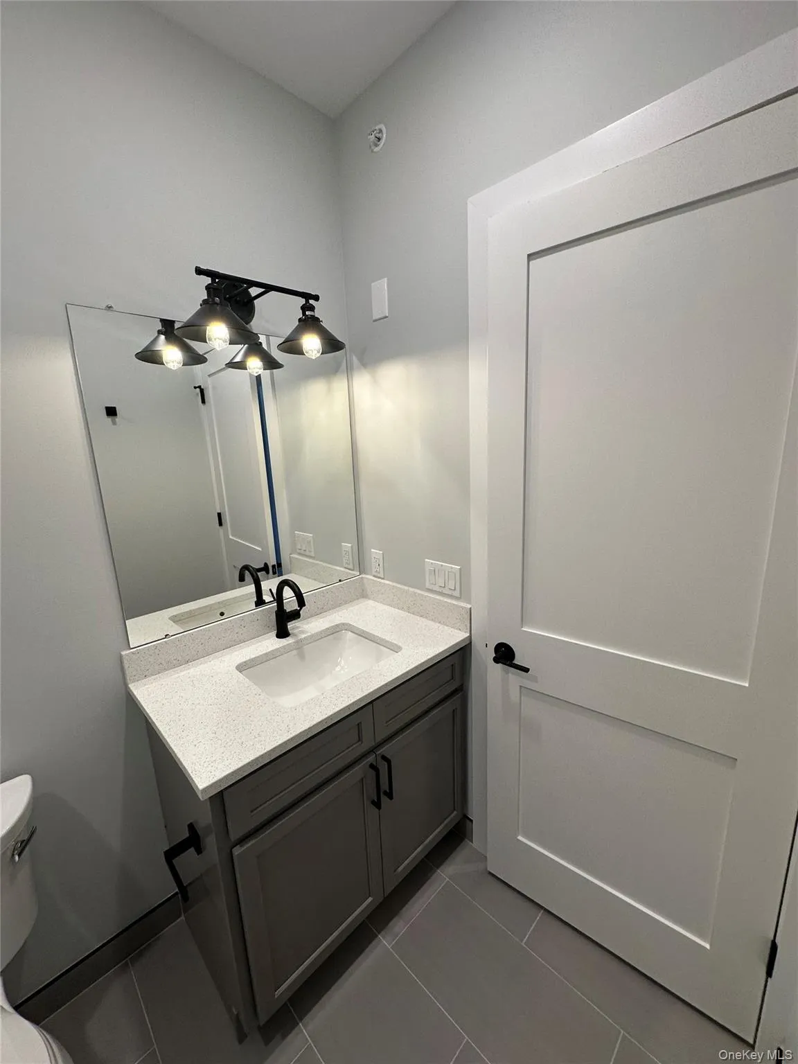 Bathroom featuring tile patterned flooring, vanity, and toilet Bathroom featuring tile patterned flooring, vanity, and toilet