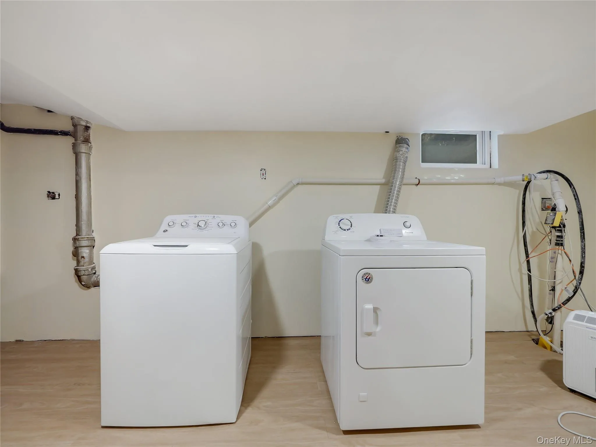 Laundry room featuring washer and clothes dryer and light wood-style flooring Laundry room featuring washer and clothes dryer and light wood-style flooring