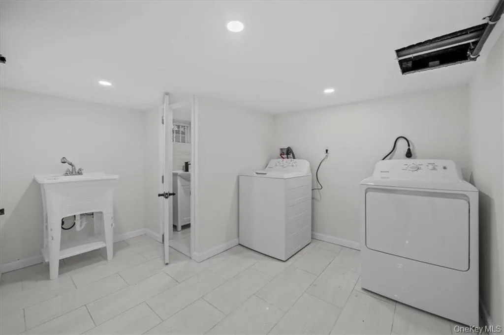 Laundry room featuring washing machine and dryer and recessed lighting Laundry room featuring washing machine and dryer and recessed lighting