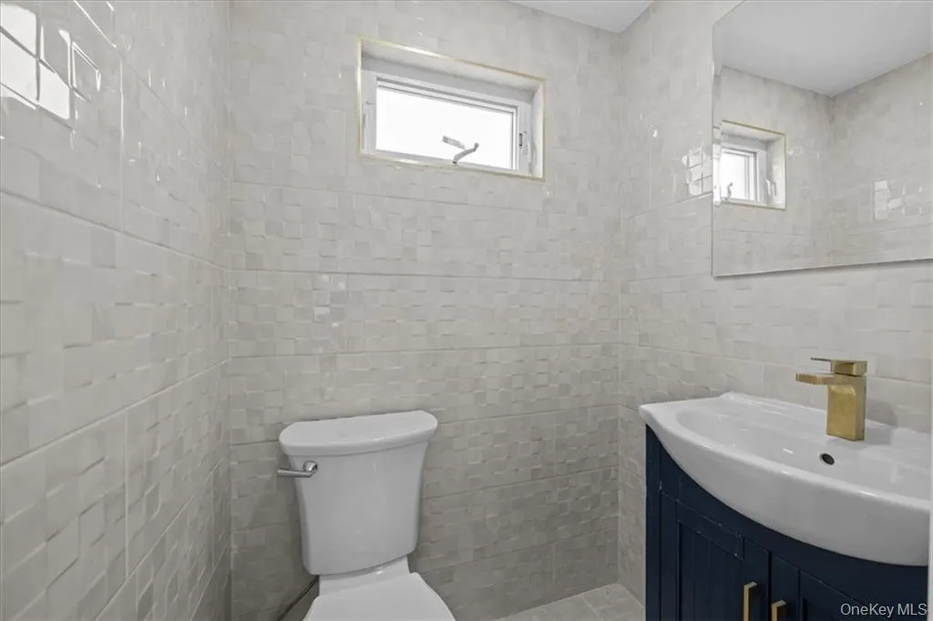 Half bathroom with vanity and tile walls Half bathroom with vanity and tile walls