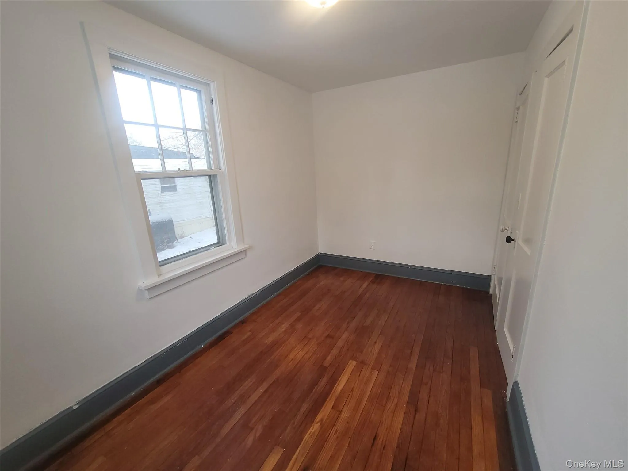 Empty room featuring baseboards and dark wood finished floors Empty room featuring baseboards and dark wood finished floors