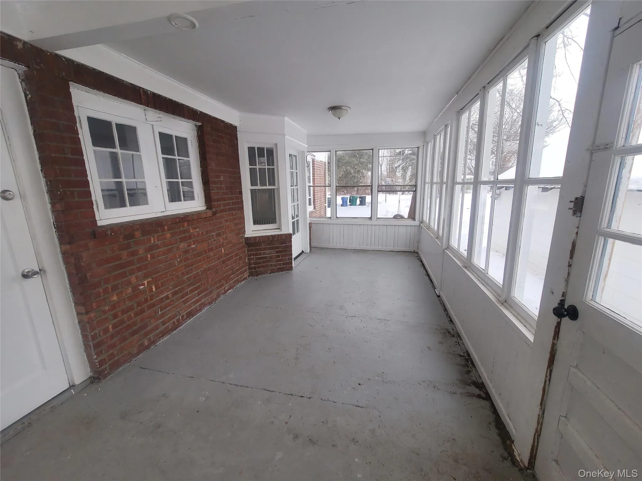 Unfurnished sunroom with concrete flooring Unfurnished sunroom with concrete flooring