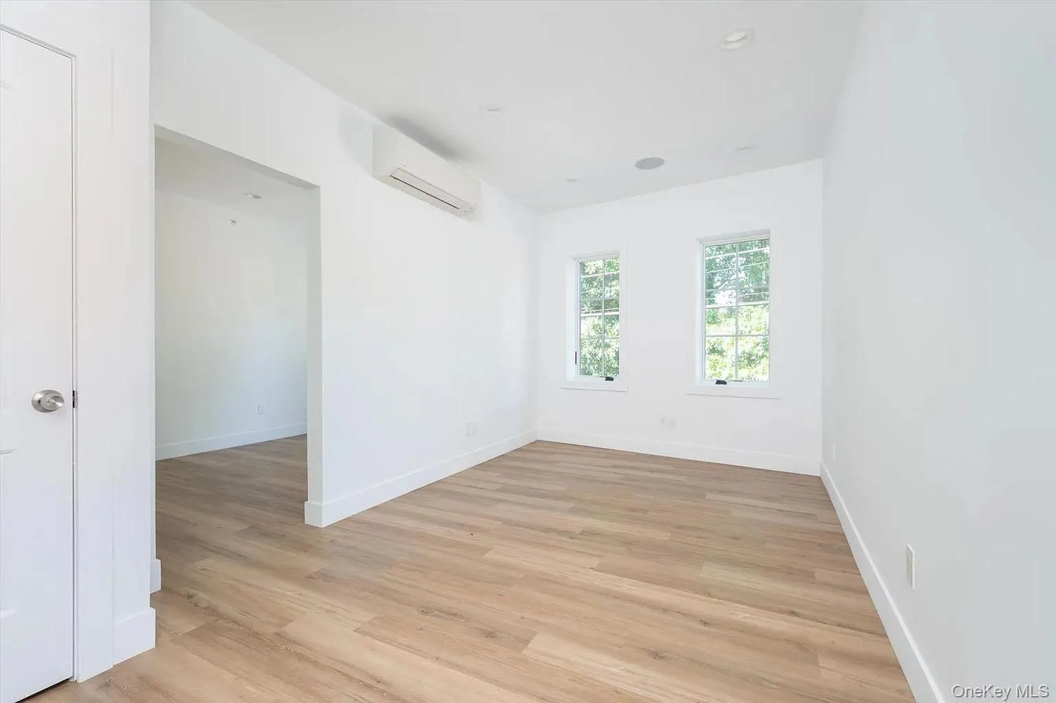 Spare room with light wood-style flooring, a wall unit AC, and recessed lighting Spare room with light wood-style flooring, a wall unit AC, and recessed lighting