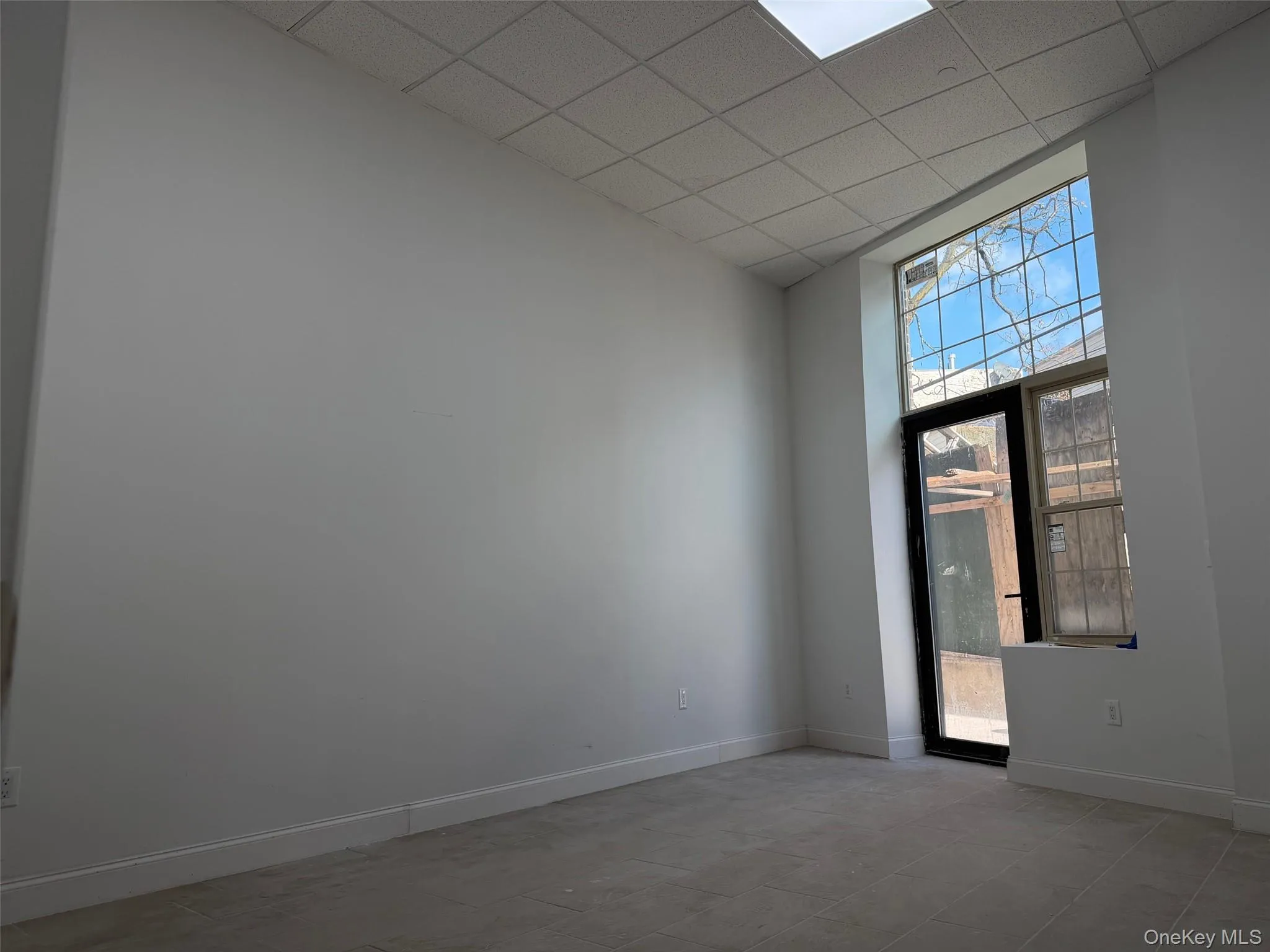 Unfurnished room with a high ceiling and a drop ceiling Unfurnished room with a high ceiling and a drop ceiling