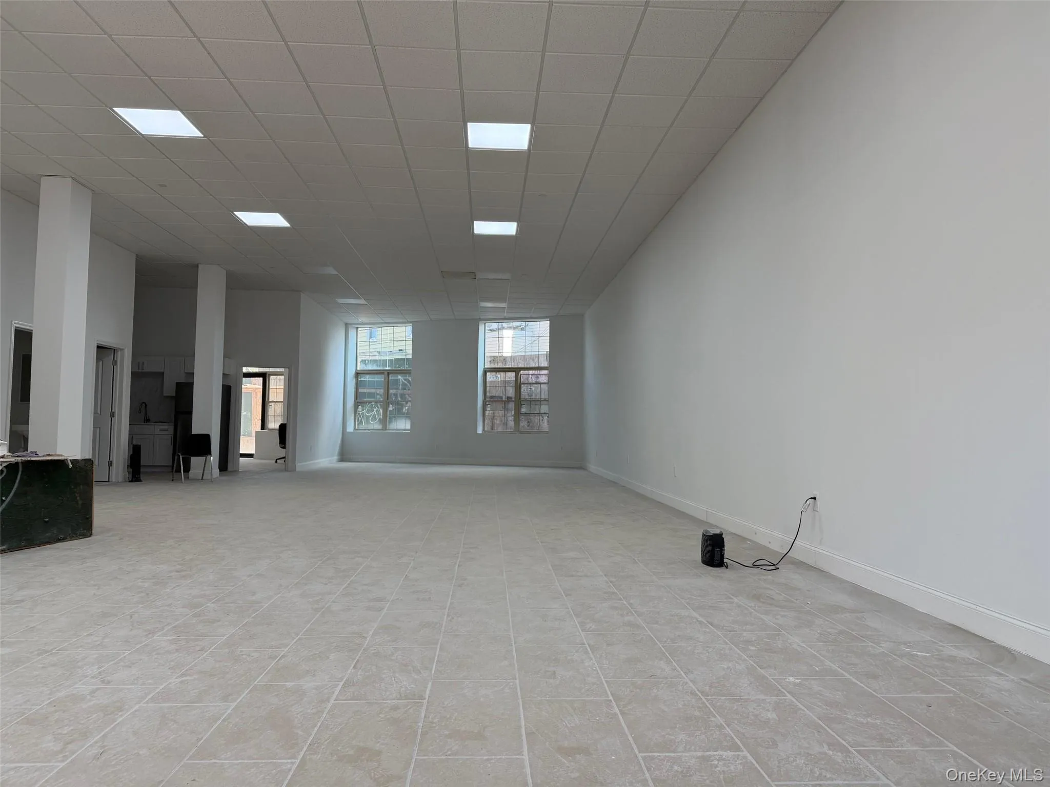 Empty room featuring a paneled ceiling and baseboards Empty room featuring a paneled ceiling and baseboards