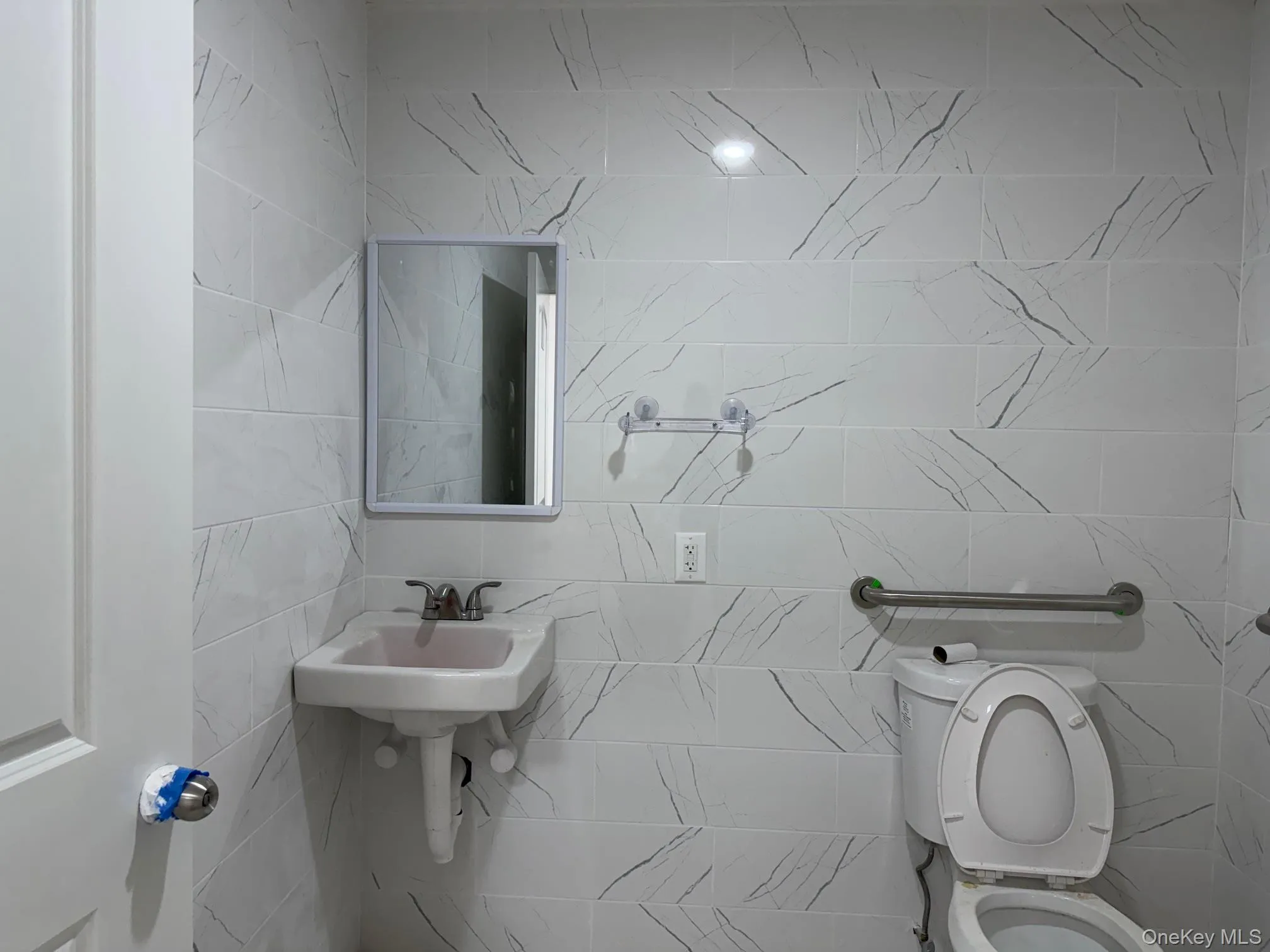 Half bath with tile walls and toilet Half bath with tile walls and toilet
